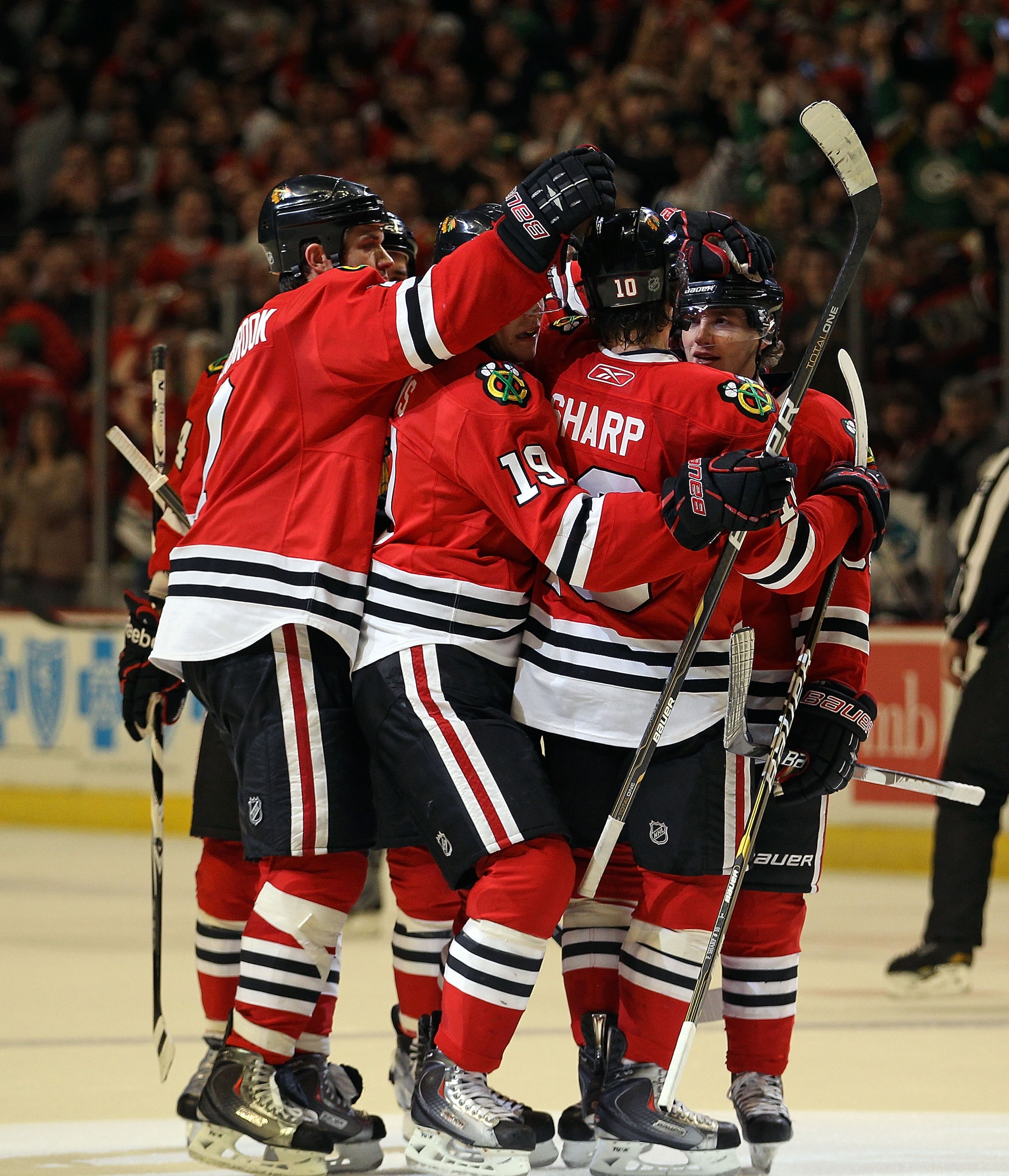 CHICAGO, IL - MARCH 14: (L-R) Brent Seabrook #7, Jonathan Toews #19 and Patrick Sharp #10 of the Chicago Blackhawks celebrate with Patrick Kane #88 after Kane scored the one hundredth goal of his career in the 2nd period against the San Jose Sharks at the