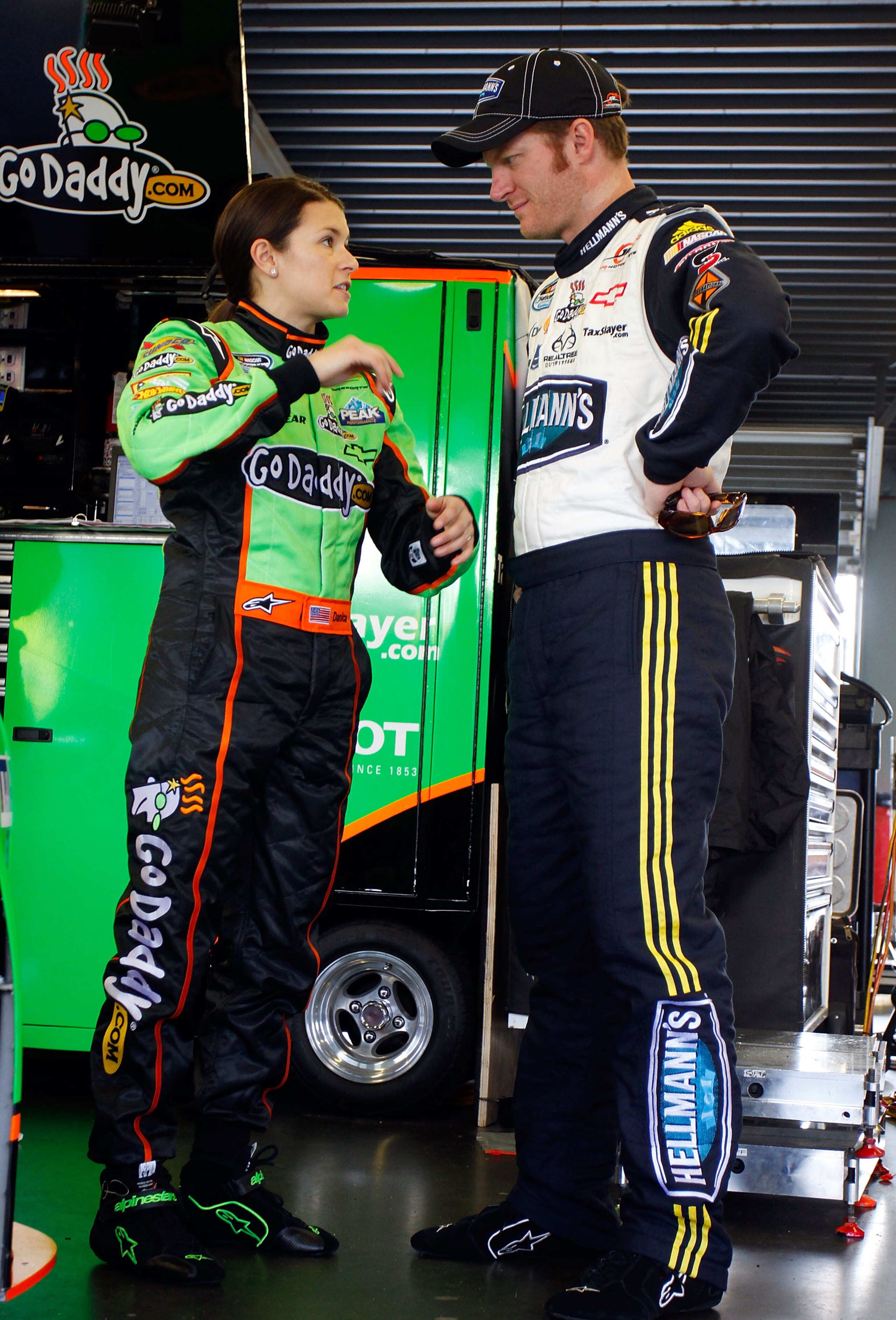 DAYTONA BEACH, FL - FEBRUARY 17:  Danica Patrick (L), driver of the #7 GoDaddy.com Chevrolet, talks with Dale Earnhardt Jr. (R), driver of the #5 Hellmann's Chevrolet, in the garage during practice for the NASCAR Nationwide Series DRIVE4COPD 300 at Dayton