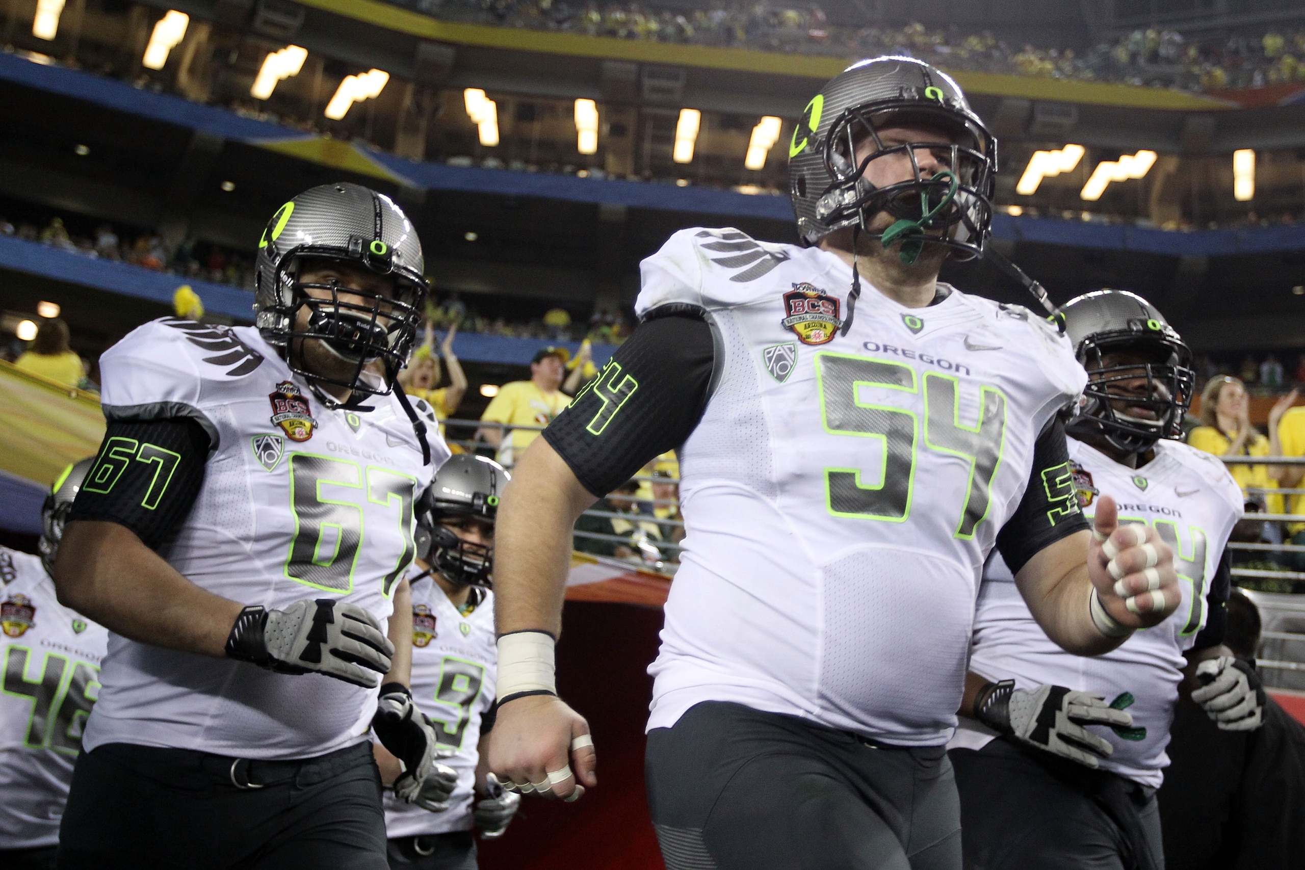 GLENDALE, AZ - JANUARY 10:  Jordan Holmes #54 and Josh Sanford #67 of the Oregon Ducks take the field for their game against the Auburn Tigers at the Tostitos BCS National Championship Game at University of Phoenix Stadium on January 10, 2011 in Glendale,