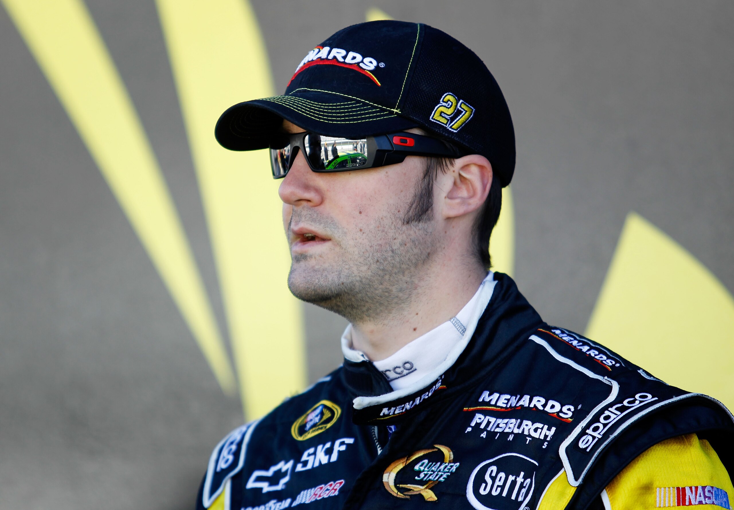DAYTONA BEACH, FL - FEBRUARY 12:  Paul Menard, driver of the #27 Menards Chevrolet, stands in the garage area during practice for the NASCAR Sprint Cup Series Daytona 500 at Daytona International Speedway on February 12, 2011 in Daytona Beach, Florida.  (