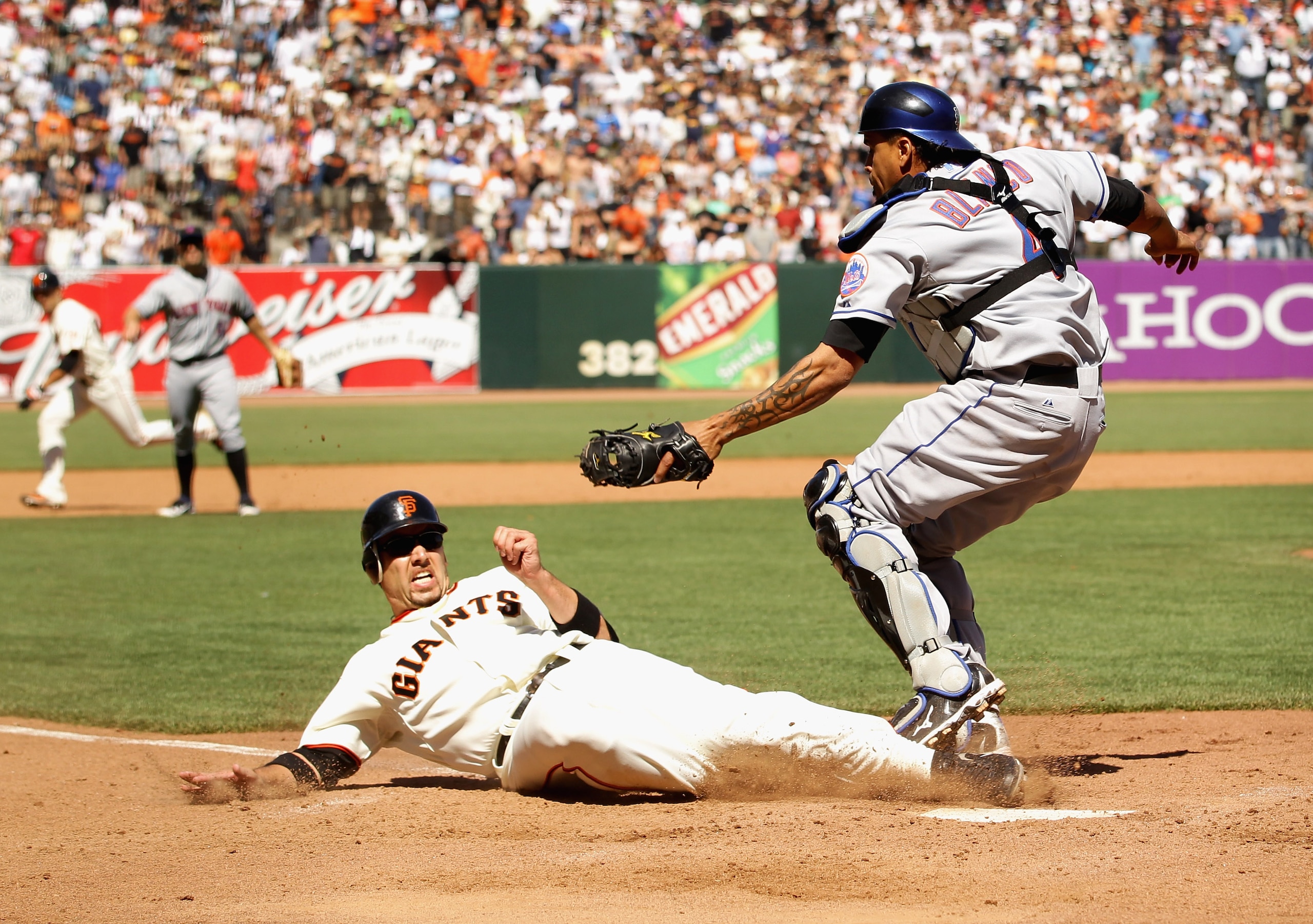 SAN FRANCISCO - JULY 18:  Travis Ishikawa #10 of the San Francisco Giants slides in to home plate under the tag of New York Mets catcher Henry Blanco #4 in the ninth inning AT&T Park on July 18, 2010 in San Francisco, California. Ishikawa was called out o