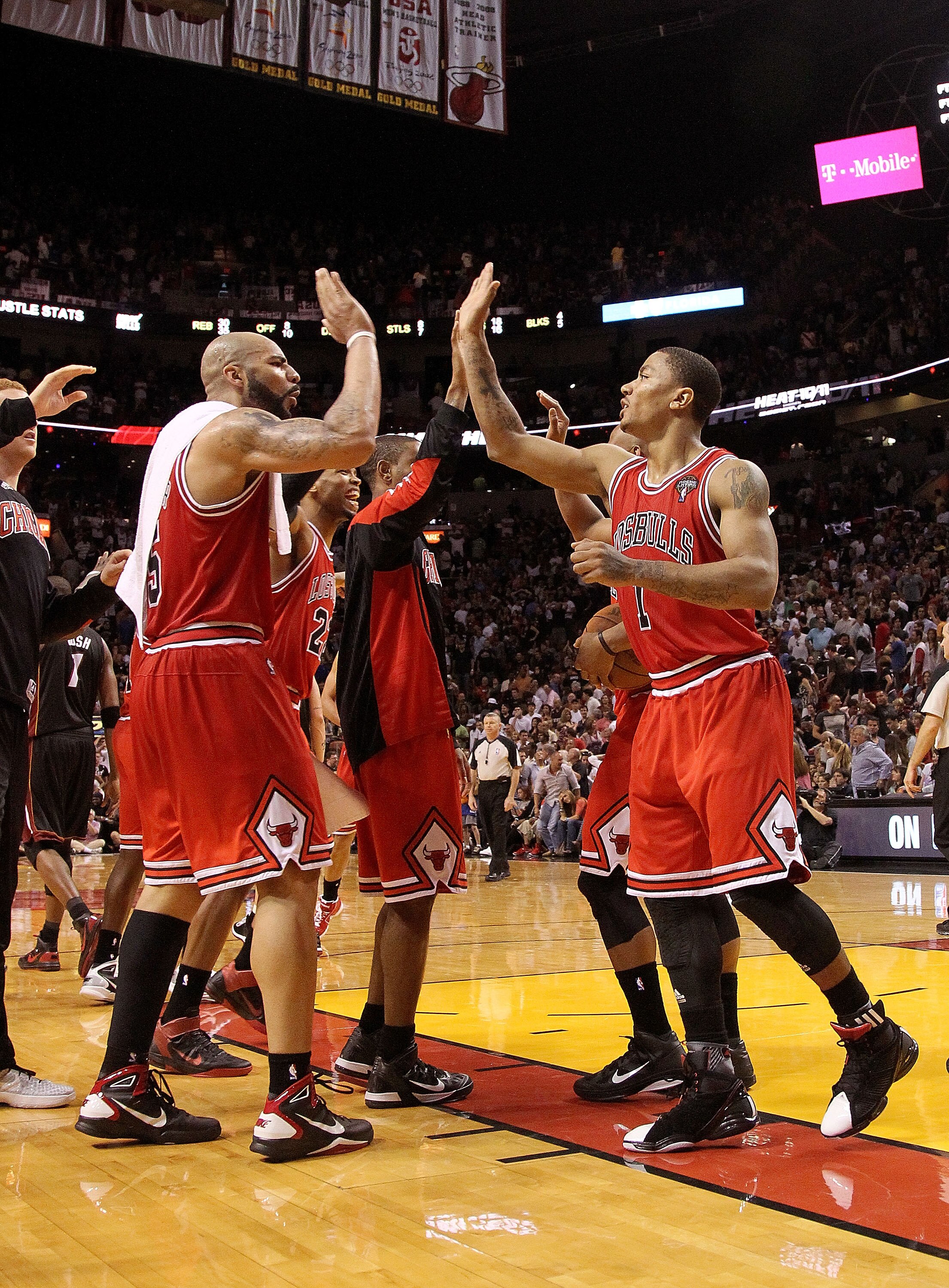 MIAMI, FL - MARCH 06:  Derrick Rose #1 and Carlos Boozer #5 of the Chicago Bulls high five after winning a game against the Miami Heat at American Airlines Arena on March 6, 2011 in Miami, Florida. NOTE TO USER: User expressly acknowledges and agrees that