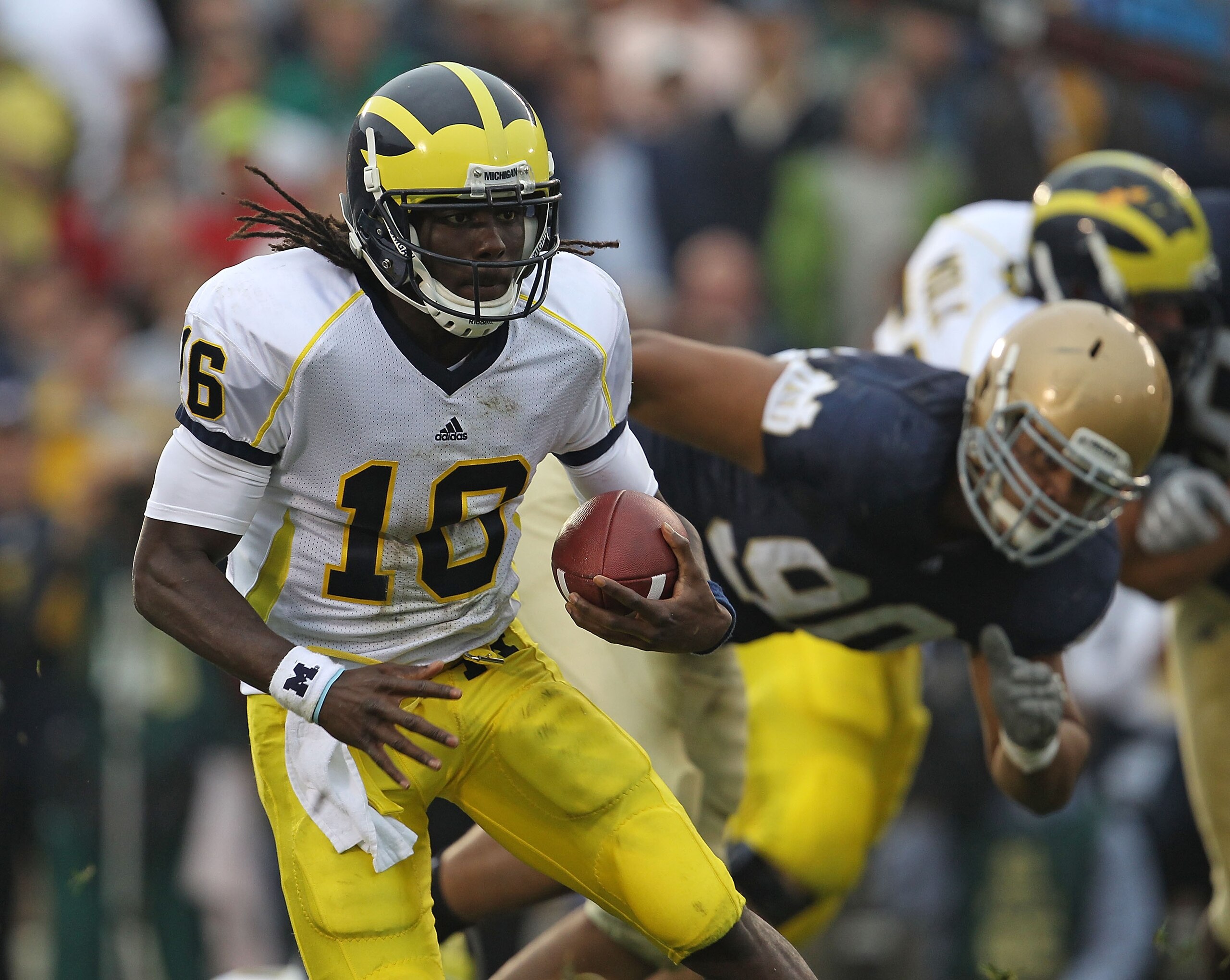 SOUTH BEND, IN - SEPTEMBER 11: Denard Robinson #16 of the Michigan Wolverines runs past Ethan Johnson #90 of the Notre Dame Fighting Irish at Notre Dame Stadium on September 11, 2010 in South Bend, Indiana. Michigan defeated Notre Dame 28-24. (Photo by Jo