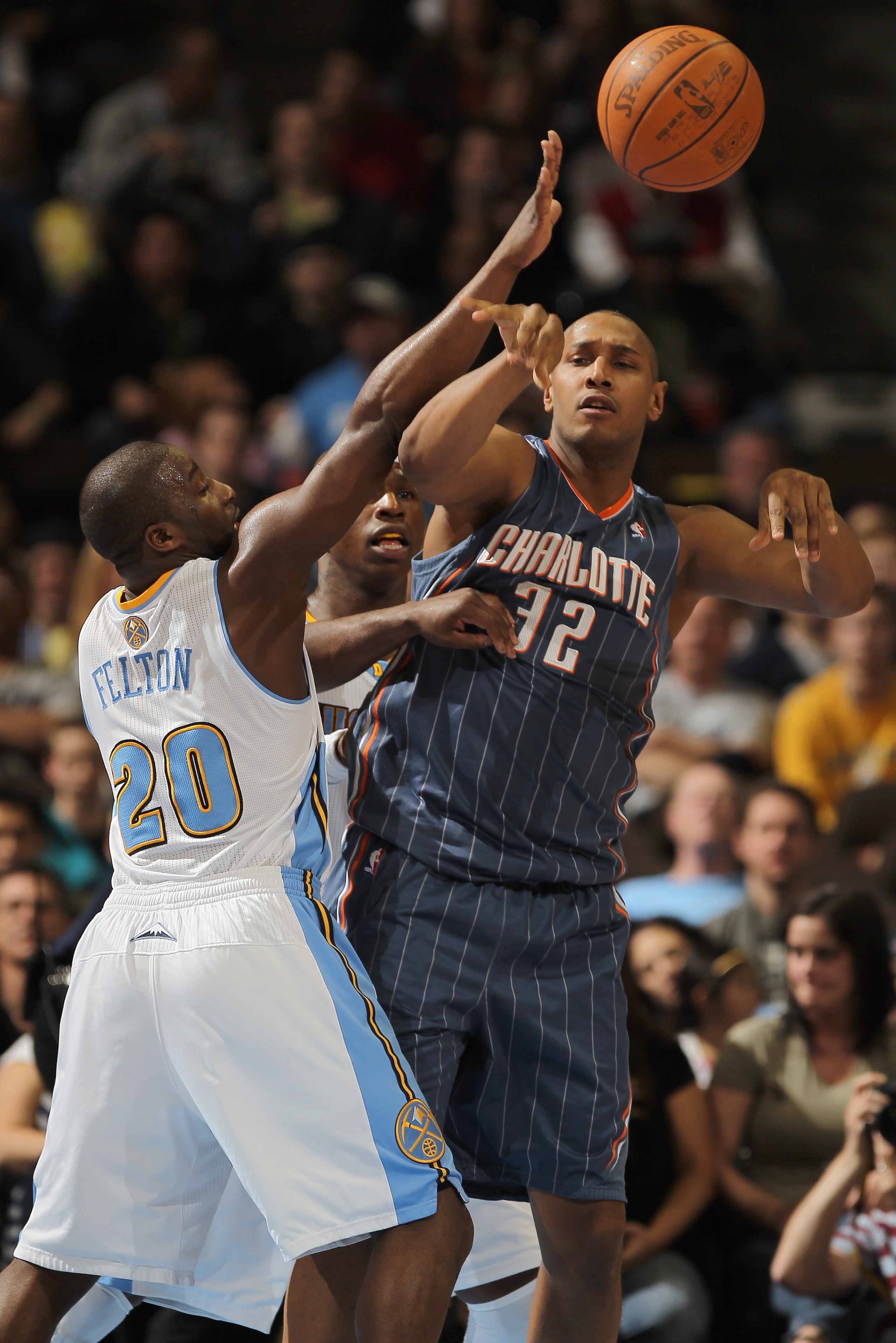 DENVER, CO - MARCH 02:  Boris Diaw #32 of the Charlotte Bobcats dishes the ball off against the defense of Raymond Felton #20 of the Denver Nuggets at the Pepsi Center on March 2, 2011 in Denver, Colorado. NOTE TO USER: User expressly acknowledges and agr