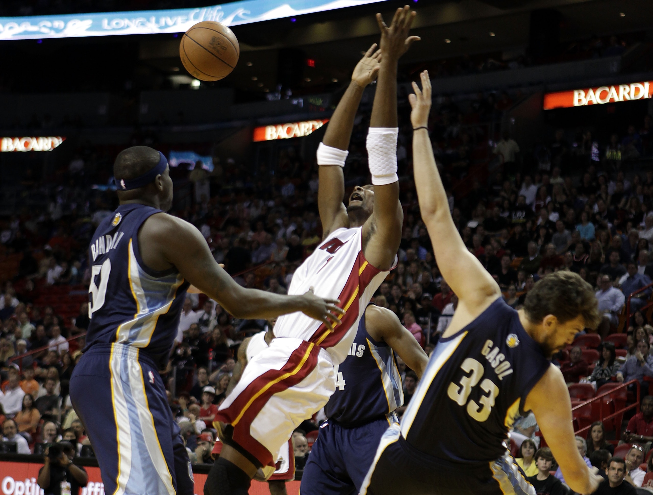 MIAMI - MARCH 12:  Forward Chris Bosh #1 of the Miami Heat drives against Zach randolph #50 (L) and Marc Gasol #33 of the Memphis Grizzlies at American Airlines Arena on March 12, 2011 in Miami, Florida. NOTE TO USER: User expressly acknowledges and agree