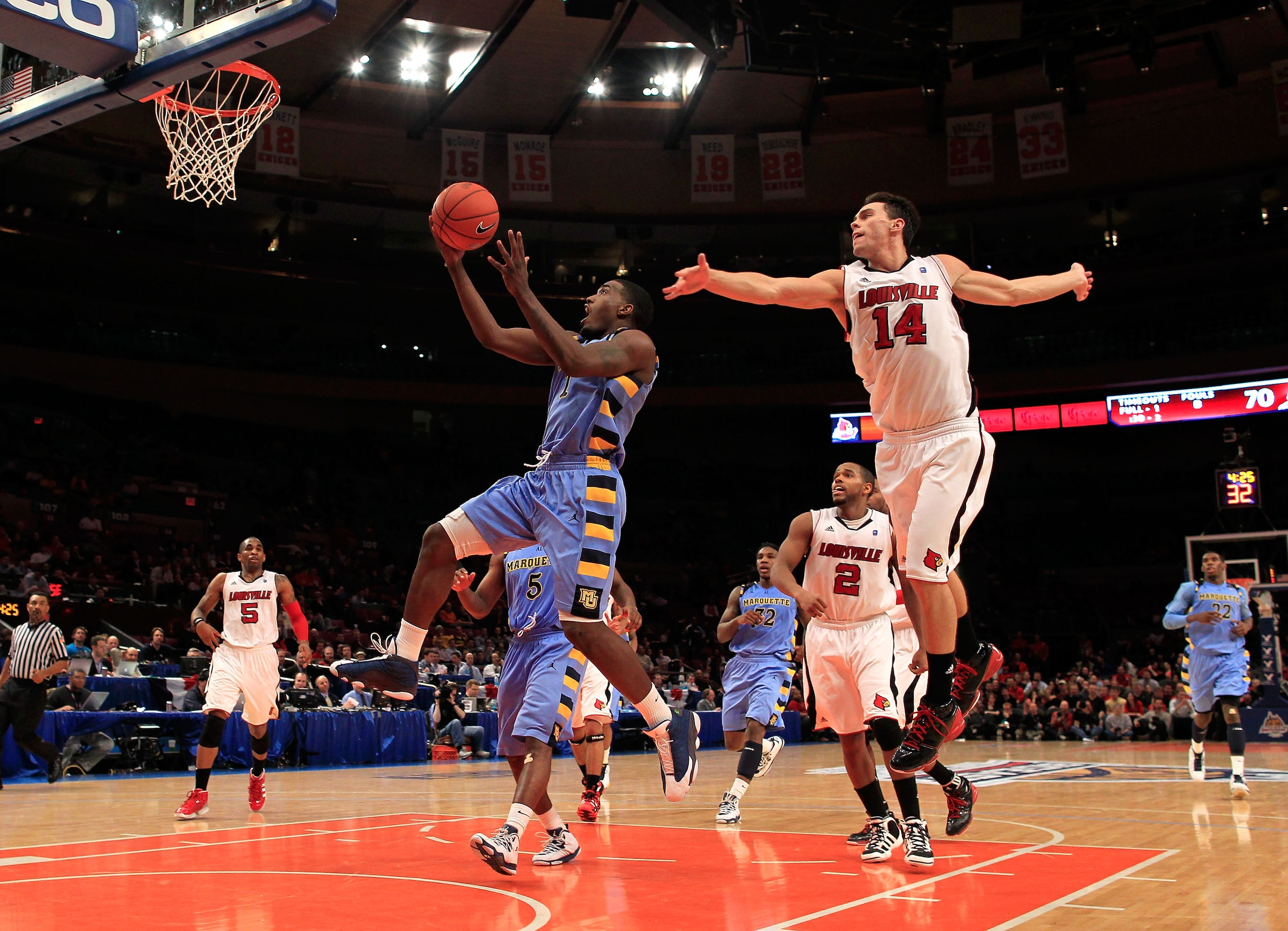 NEW YORK, NY - MARCH 10: Darius Johnson-Odom #1 of the Marquette Golden Eagles drives to the basket against Kyle Kuric #14 of the Louisville Cardinals during the quarterfinals of the 2011 Big East Men's Basketball Tournament presented by American Eagle Ou