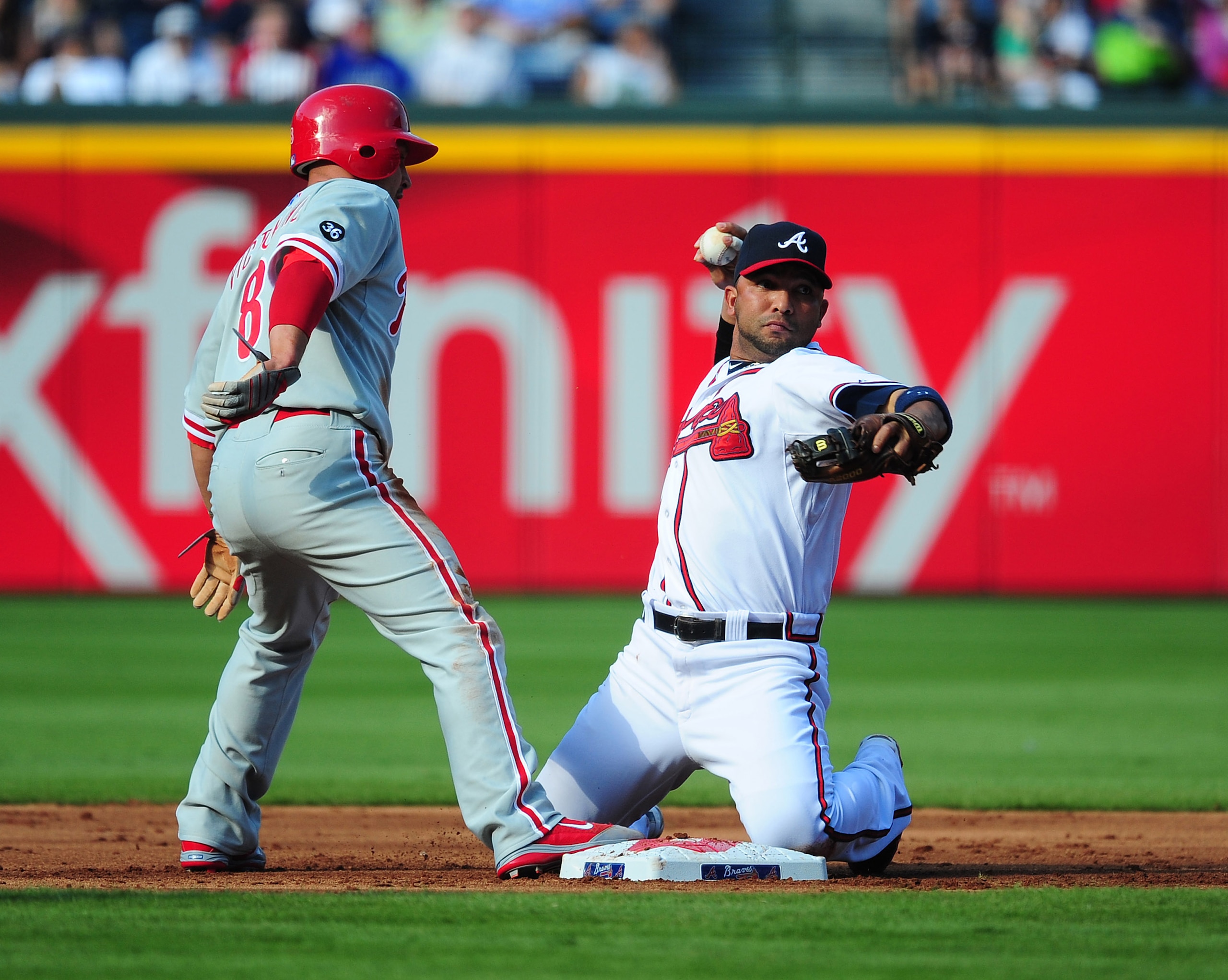 ATLANTA - OCTOBER 2: Alex Gonzalez #2 the Atlanta Braves attempts to turn a double play against Shane Victorino #8 of the Philadelphia Phillies at Turner Field on October 2, 2010 in Atlanta, Georgia.  (Photo by Scott Cunningham/Getty Images)