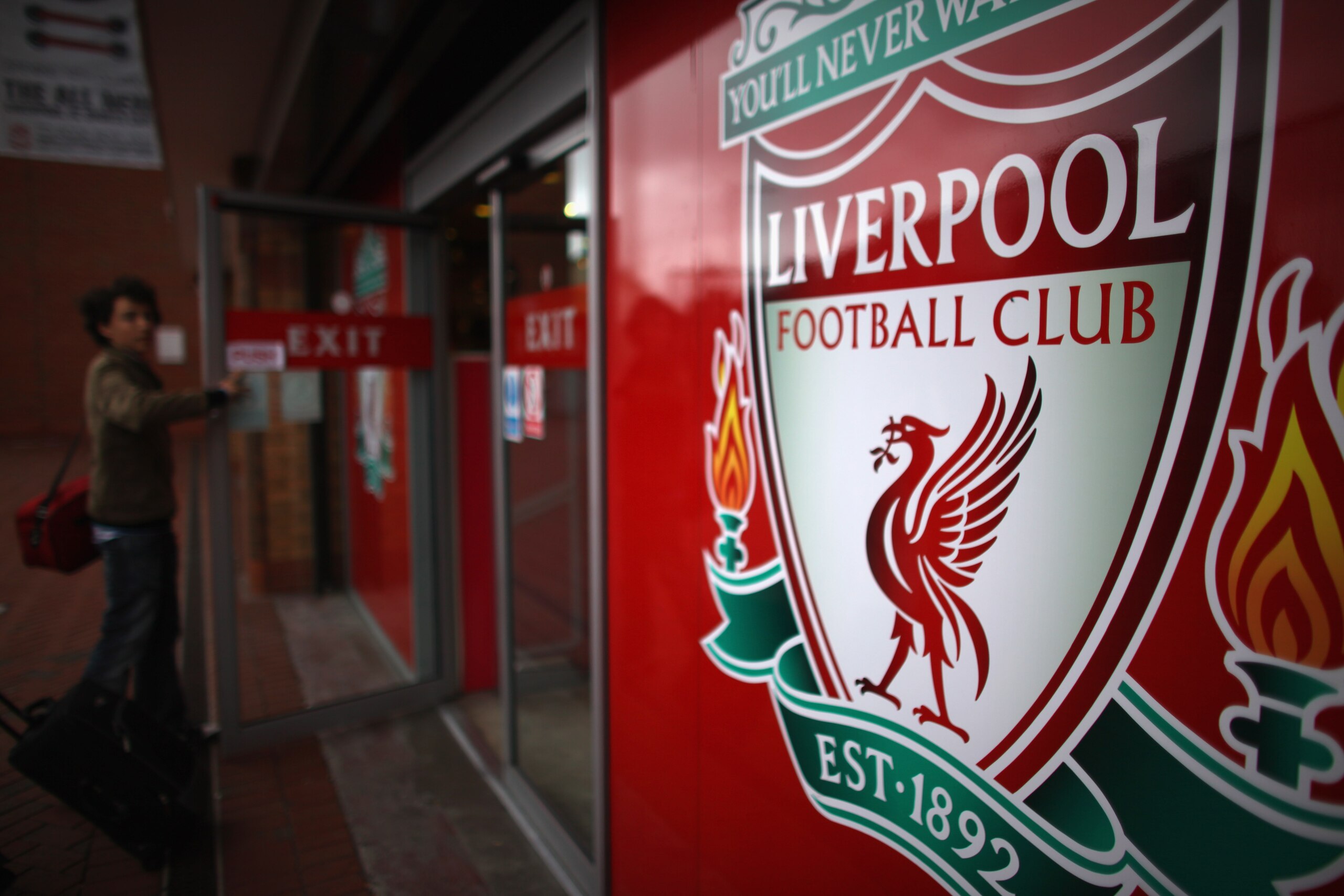 LIVERPOOL, ENGLAND - OCTOBER 15: Fans leave the club shop at Liverpool Football Club as plans on a buy out by American sports company NESV continues on October 15, 2010 in Liverpool, England. The future ownership of the famous football club had been subj LIVERPOOL, ENGLAND - OCTOBER 15: Fans leave the club shop at Liverpool Football Club as plans on a buy out by American sports company NESV continues on October 15, 2010 in Liverpool, England. The future ownership of the famous football club had been subj