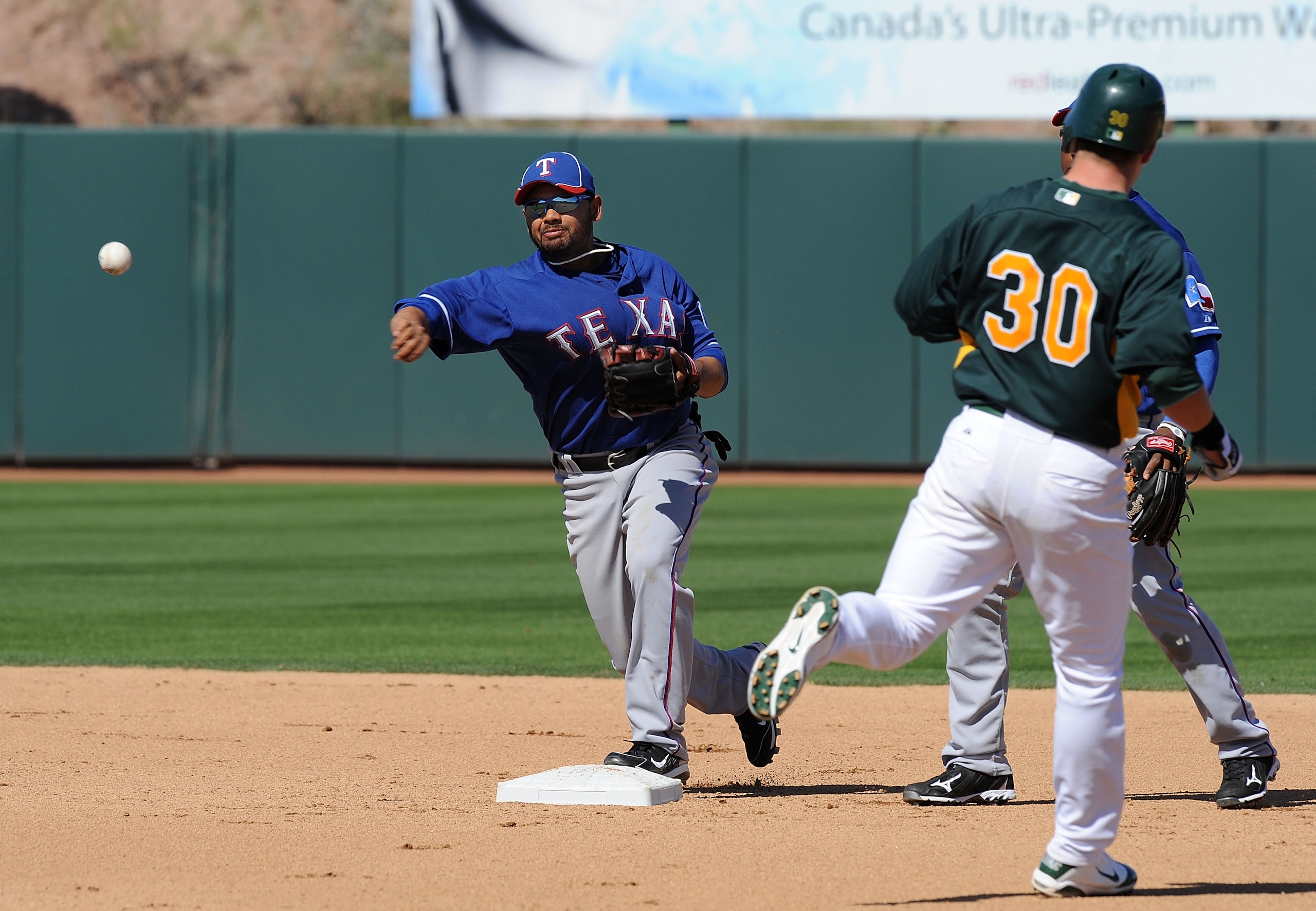 PHOENIX, AZ - MARCH 04:  Andres Blanco #3 of the Texas Rangers attempts to turn a double play against the Oakland Athletics at Phoenix Municipal Stadium on March 4, 2011 in Phoenix, Arizona.  (Photo by Norm Hall/Getty Images)