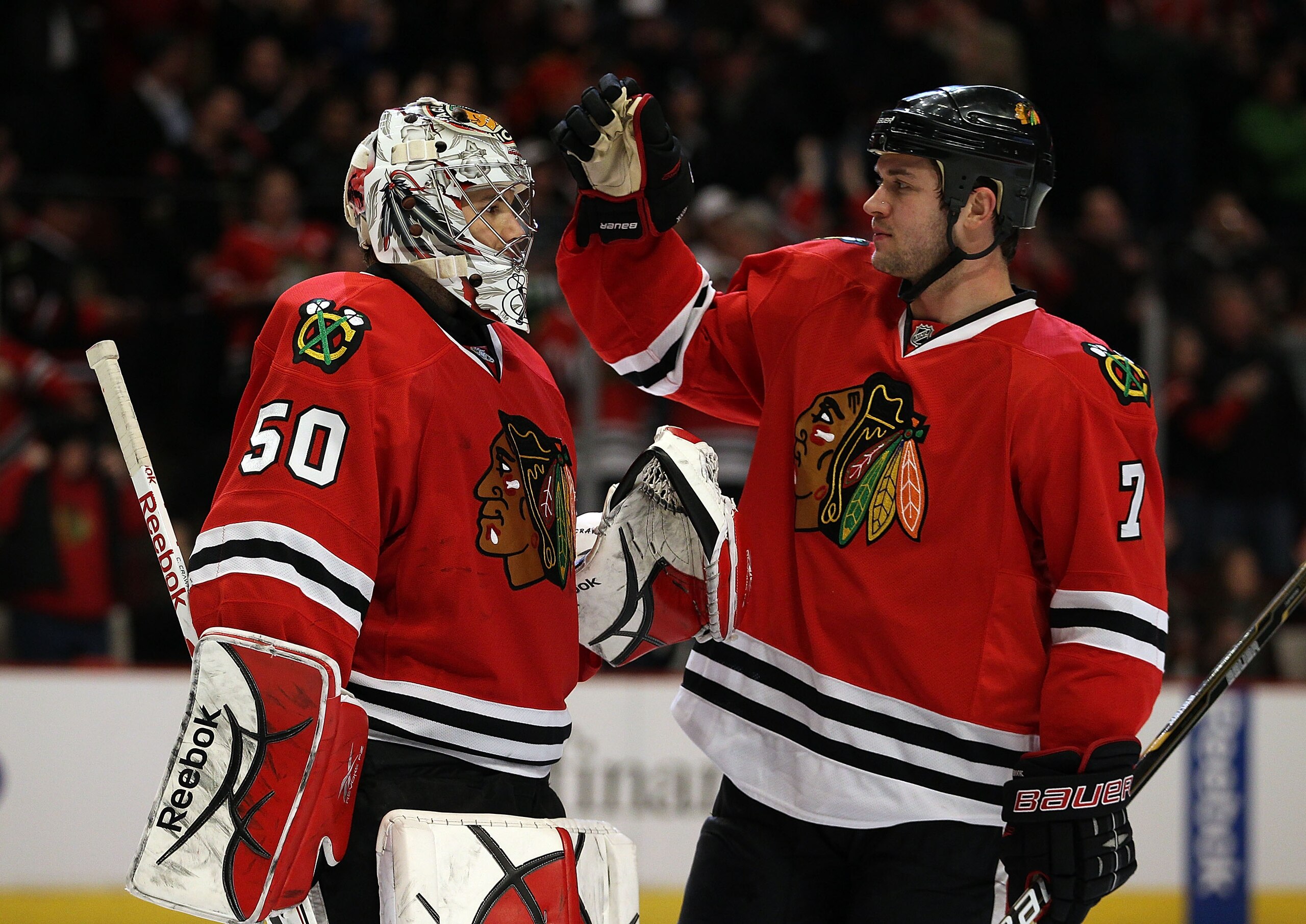 CHICAGO, IL - MARCH 02: Brent Seabrook #7 of the Chicago Blackhawks congratulates teammate Corey Crawford #50 after a win over the Calgary Flames at the United Center on March 2, 2011 in Chicago, Illinois. The Blackhawks defeated the Flames 6-4. (Photo by