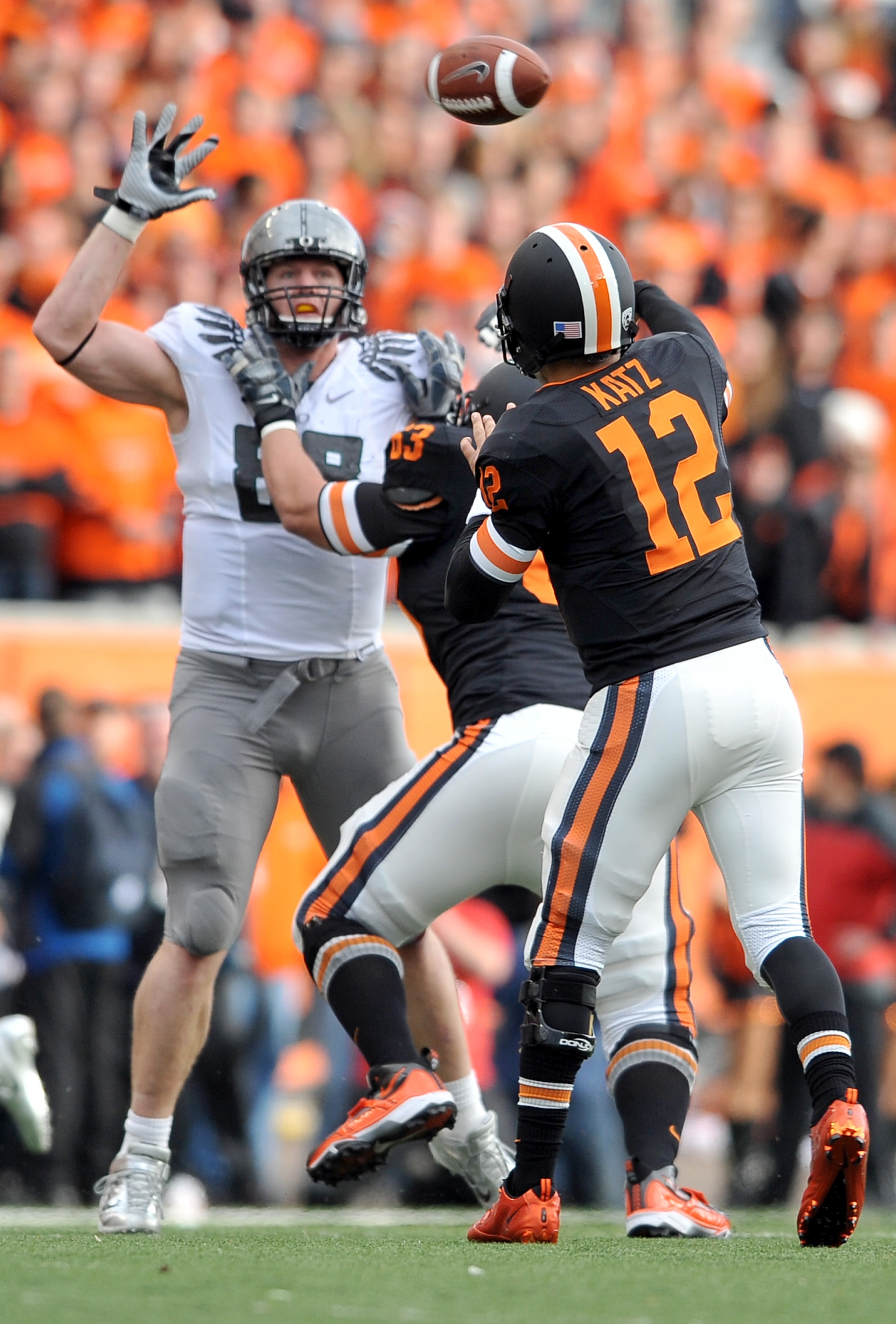 CORVALLIS, OR - DECEMBER 4: Quarterback Ryan Katz #12 of the Oregon State Beavers tries to pass the ball over the outstretched arm of Brandon Bair #88 of the Oregon Ducks in the second quarter the game at Reser Stadium on December 4, 2010 in Corvallis, Or