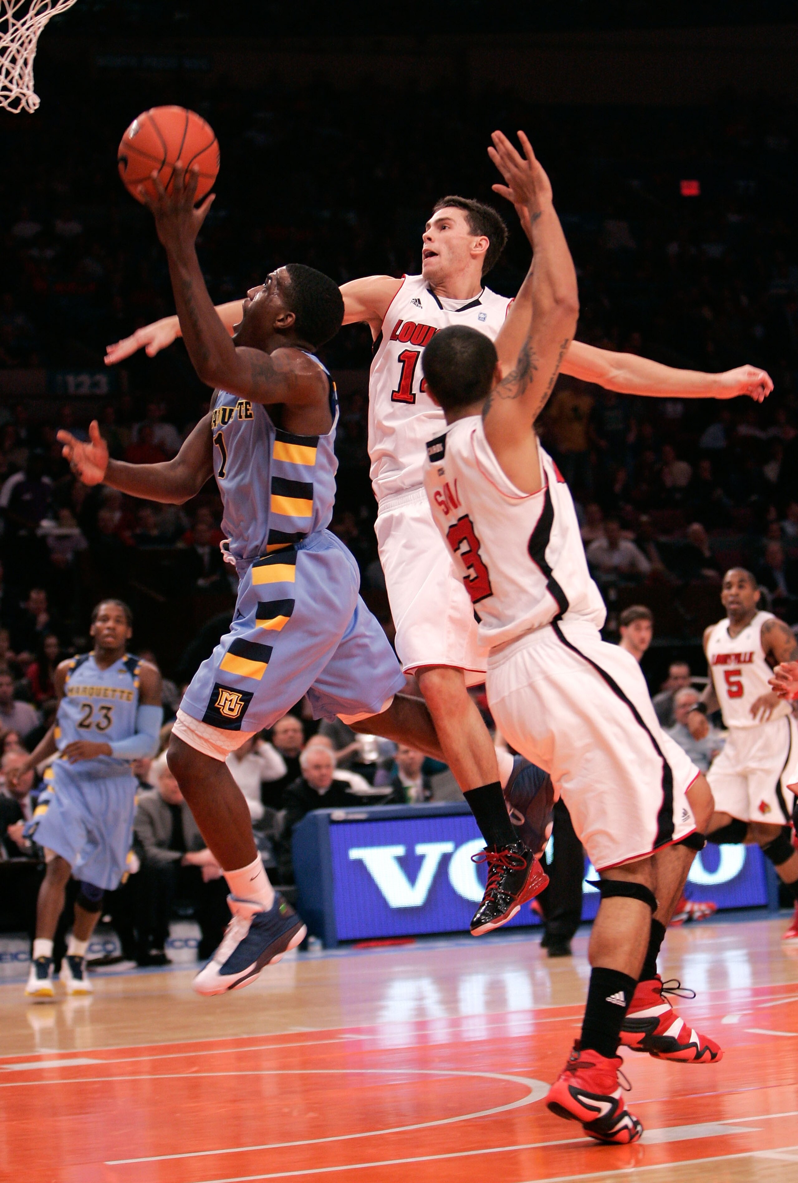 NEW YORK, NY - MARCH 10: Darius Johnson-Odom #1 of the Marquette Golden Eagles drives to the basket against Kyle Kuric #14 and Peyton Siva #3 of the Louisville Cardinals during the quarterfinals of the 2011 Big East Men's Basketball Tournament presented b