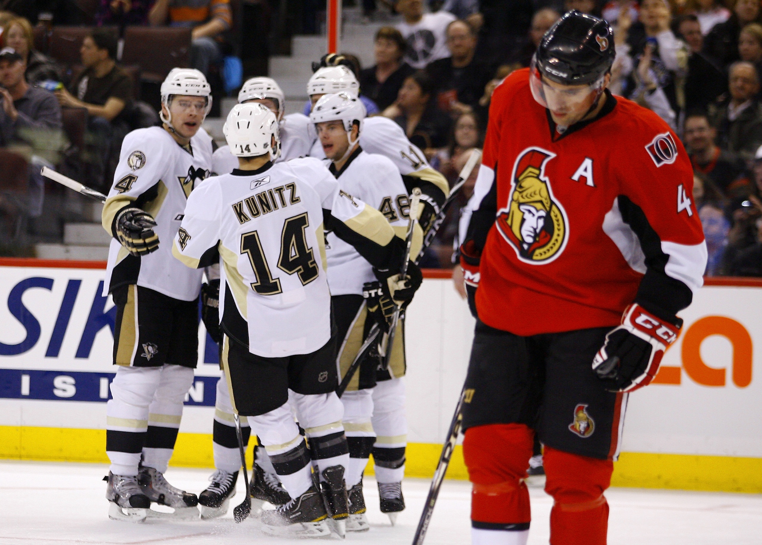 OTTAWA, CANADA - MARCH 15:  Zbynek Michalek #4;Chris Kunitz #14;Tyler Kennedy #48 and Jordan Staal #11 of the Pittsburgh Penguins celebrate a goal while Chris Phillips #4 of the Ottawa Senators skates away dejectedly in a game at Scotiabank Place on March