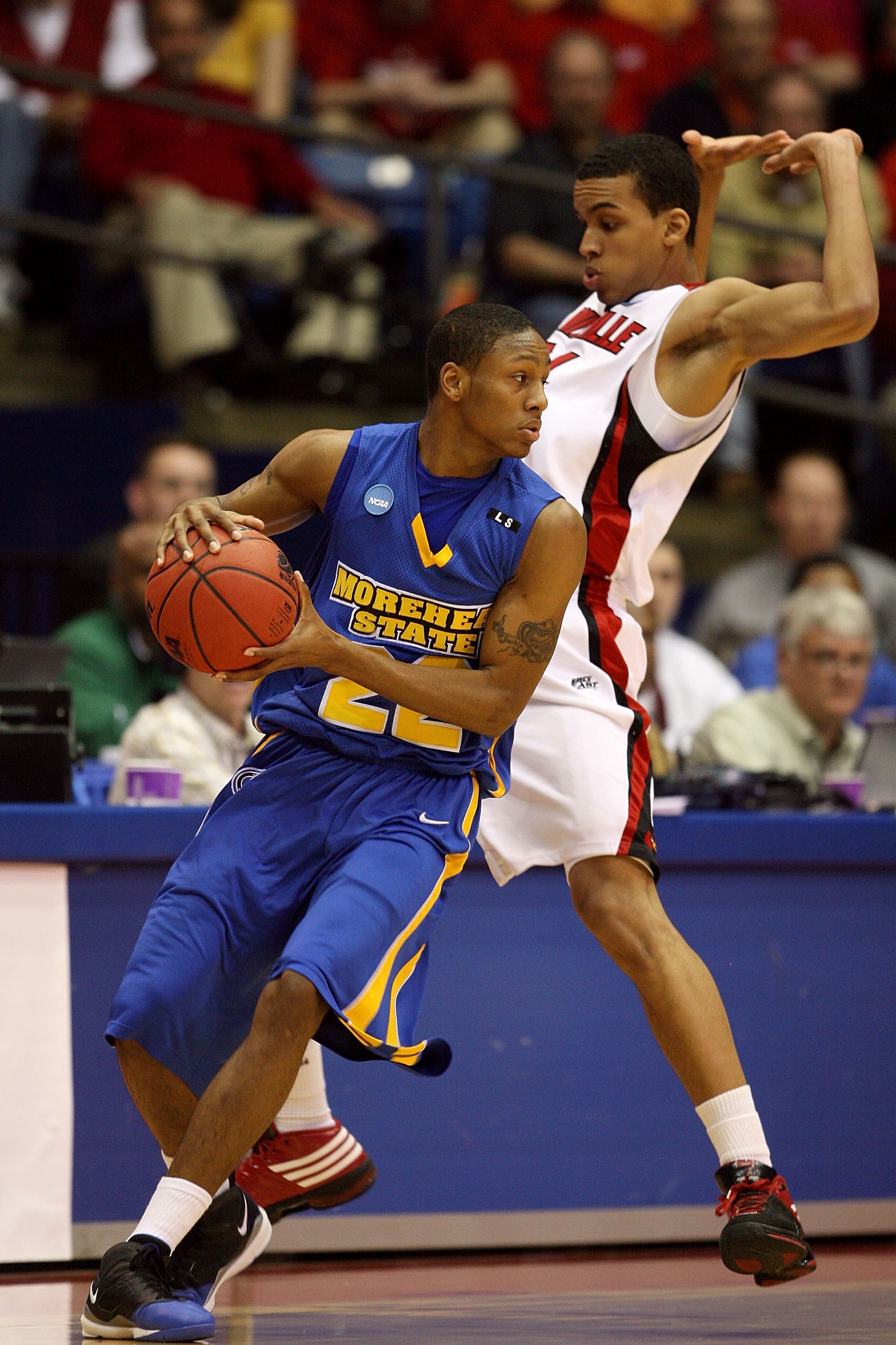 DAYTON, OH - MARCH 20: Demonte Harper #22 of the Morehead State Eagles handles the ball against Edgar Sosa #21 of the Louisville Cardinals during the first round of the NCAA Division I Men's Basketball Tournament at the University of Dayton Arena on March
