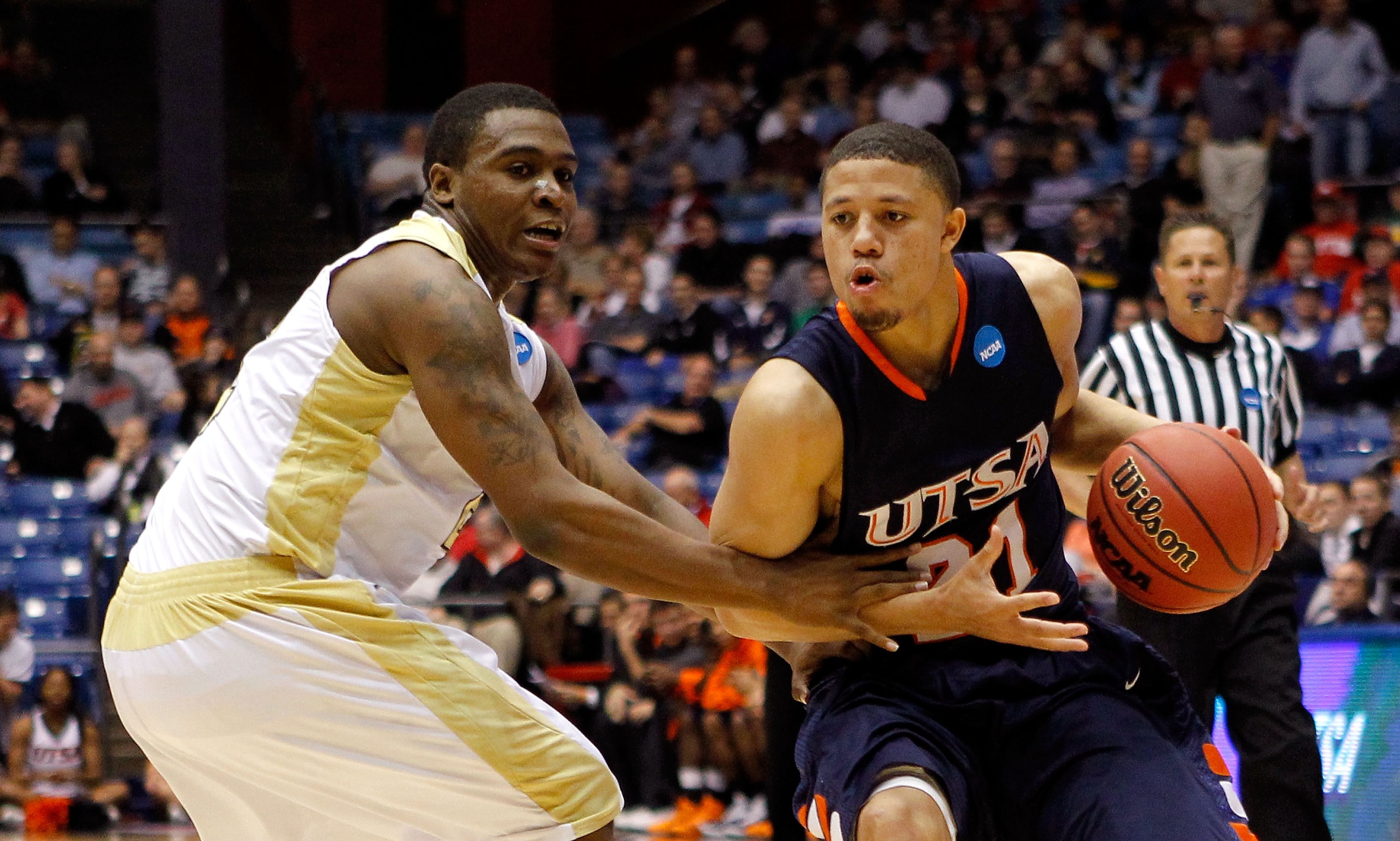 DAYTON, OH - MARCH 16: Devin Gibson #21 of the Texas-San Antonio Roadrunners handles the ball against Tramaine Butler #21 of the Alabama State Hornets during the first round of the 2011 NCAA men's basketball tournament at UD Arena on March 16, 2011 in Day