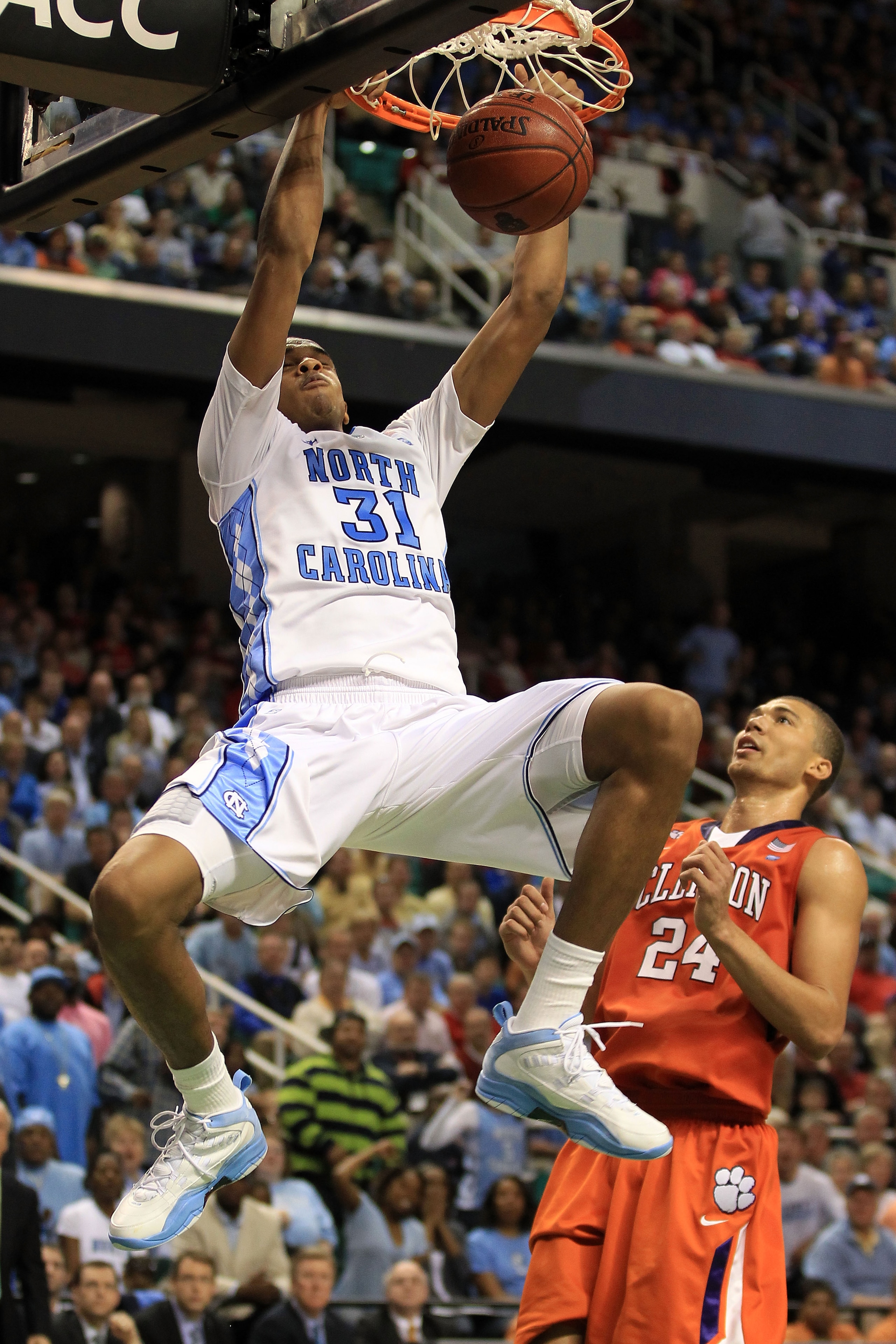 GREENSBORO, NC - MARCH 12:  John Henson #31 of the North Carolina Tar Heels dunks against Milton Jennings #24 of the Clemson Tigers during the second half in the semifinals of the 2011 ACC men's basketball tournament at the Greensboro Coliseum on March 12