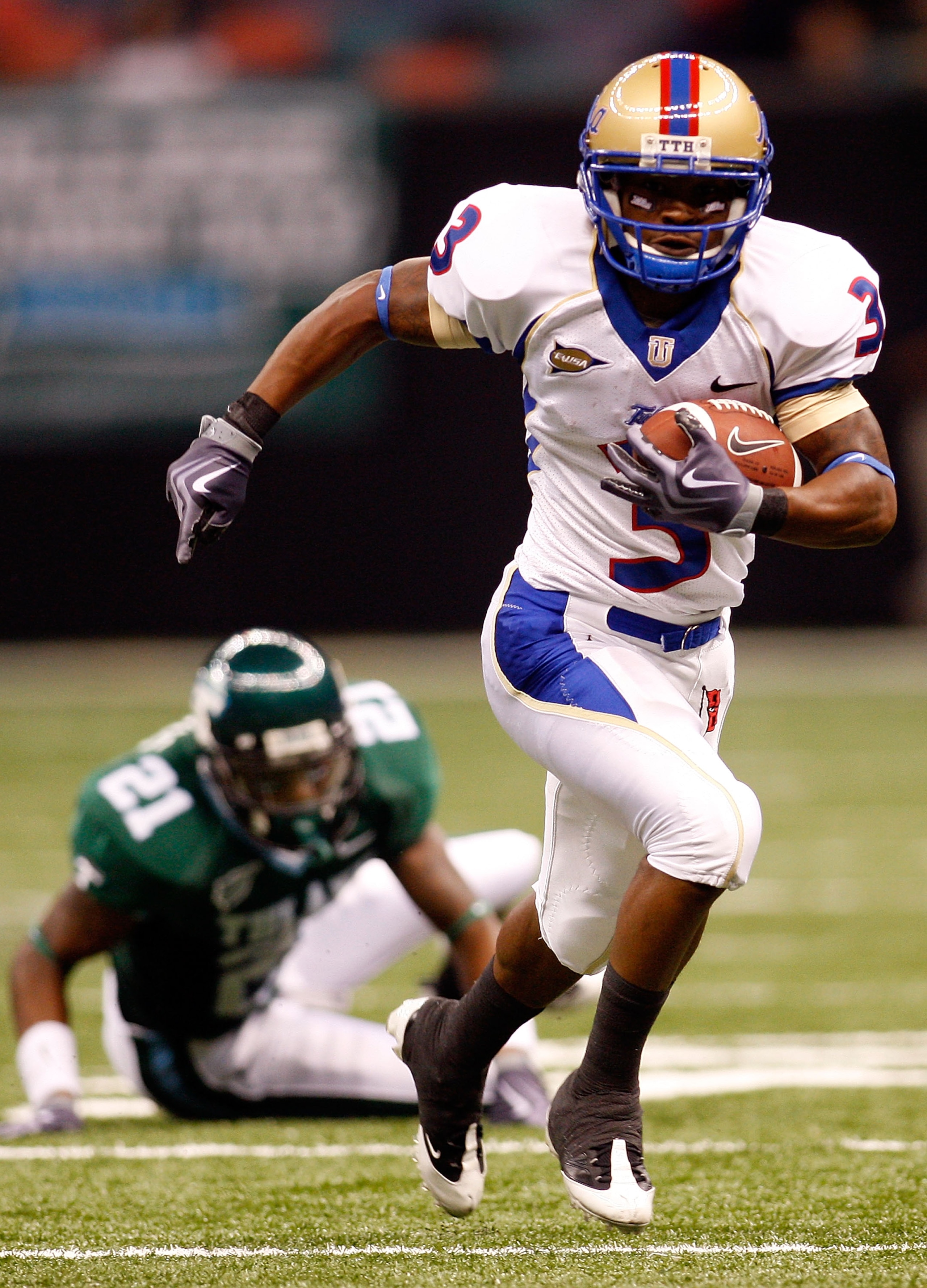 NEW ORLEANS - SEPTEMBER 04:  Damaris Johnson #3 of the Tulsa Golden Hurricanes runs past Charles Harris #21 of the Tulane Green Wave at the Louisiana Superdome on September 4, 2009 in New Orleans, Louisiana.  (Photo by Chris Graythen/Getty Images)