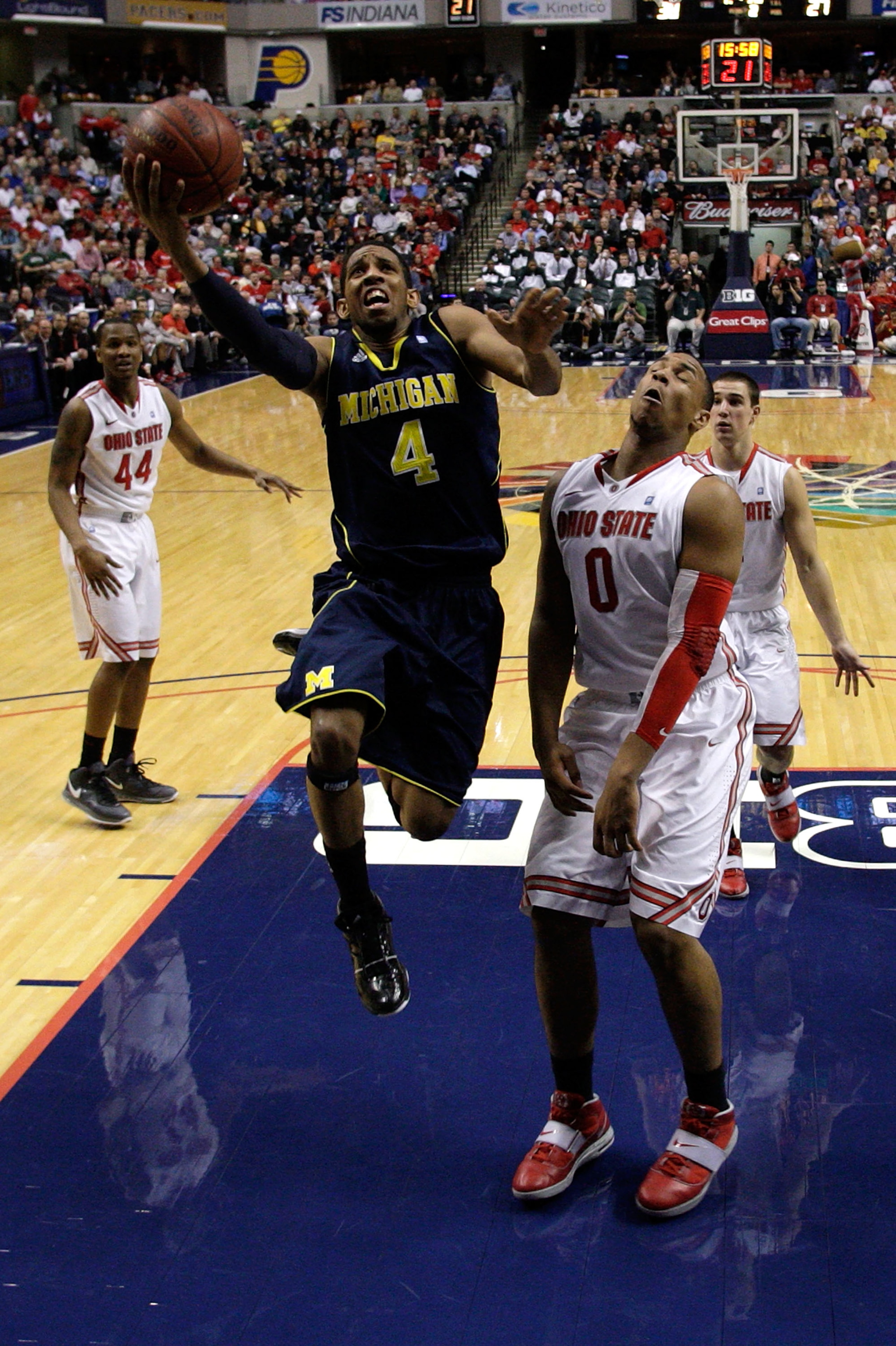 INDIANAPOLIS, IN - MARCH 12:  Darius Morris #4 of the Michigan Wolverines drives for a shot attempt against Jared Sullinger #0 of the Ohio State Buckeyes during the semifinals of the 2011 Big Ten Men's Basketball Tournament at Conseco Fieldhouse on March