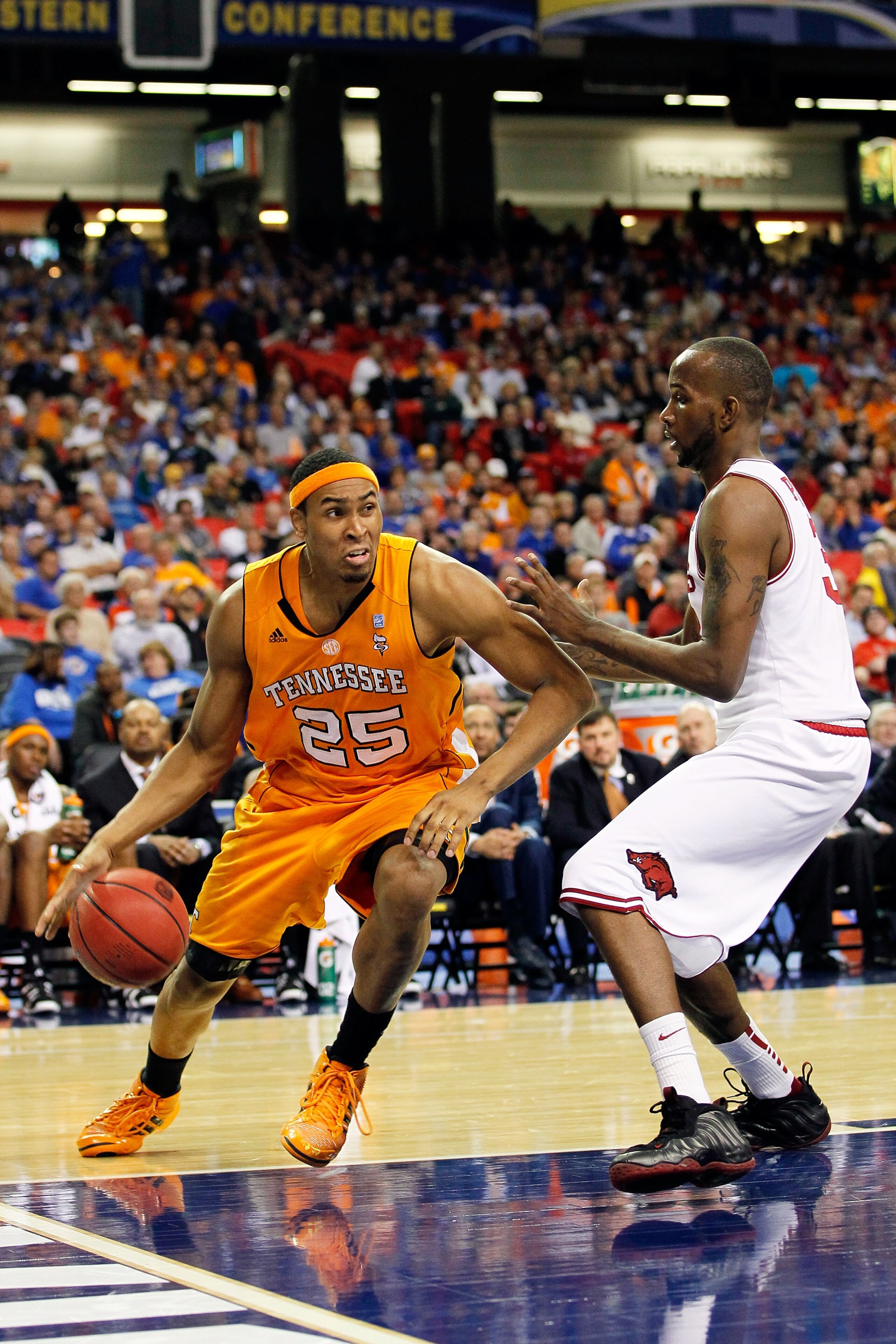 ATLANTA, GA - MARCH 10:  John Fields #25 of the Tennessee Volunteers drives past Marshawn Powell #33 of the Arkansas Razorbacks during the first round of the SEC Men's Basketball Tournament at the Georgia Dome on March 10, 2011 in Atlanta, Georgia.  (Phot