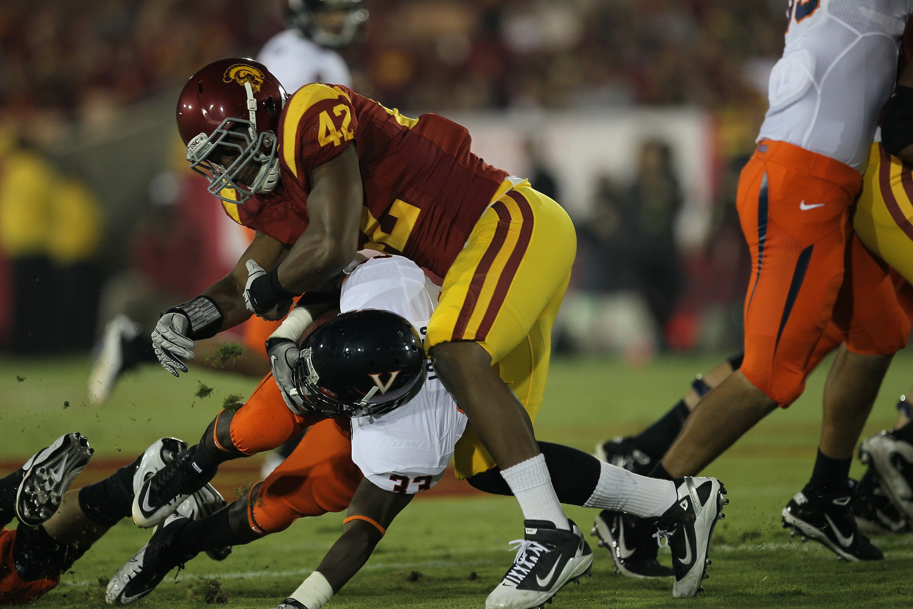 LOS ANGELES, CA - SEPTEMBER 11:  Linebacker Devon Kennard #42 of the USC Trojans tackles running back  Perry Jones #33 of the Virginia Cavaliers at Los Angeles Memorial Coliseum on September 11, 2010 in Los Angeles, California.  (Photo by Stephen Dunn/Get