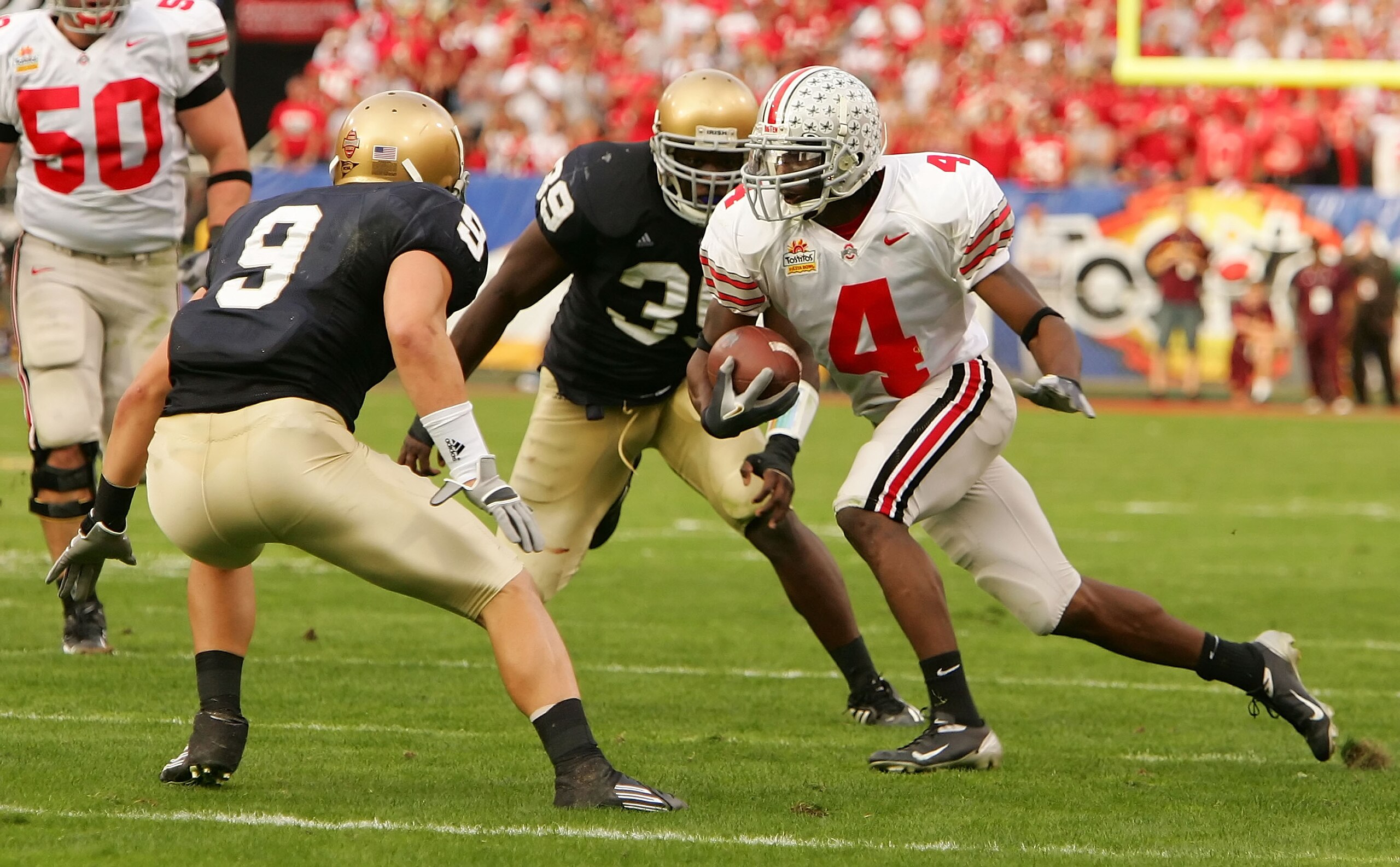 TEMPE, AZ - JANUARY 02:  Wire receiver Santonio Holmes #4 of the Ohio State Buckeyes runs after a catch as he looks to get by defensive back Tom Zbikowski #9 of the Notre Dame Fighting Irish in the Tostito's Fiesta Bowl at Sun Devil Stadium on January 2,