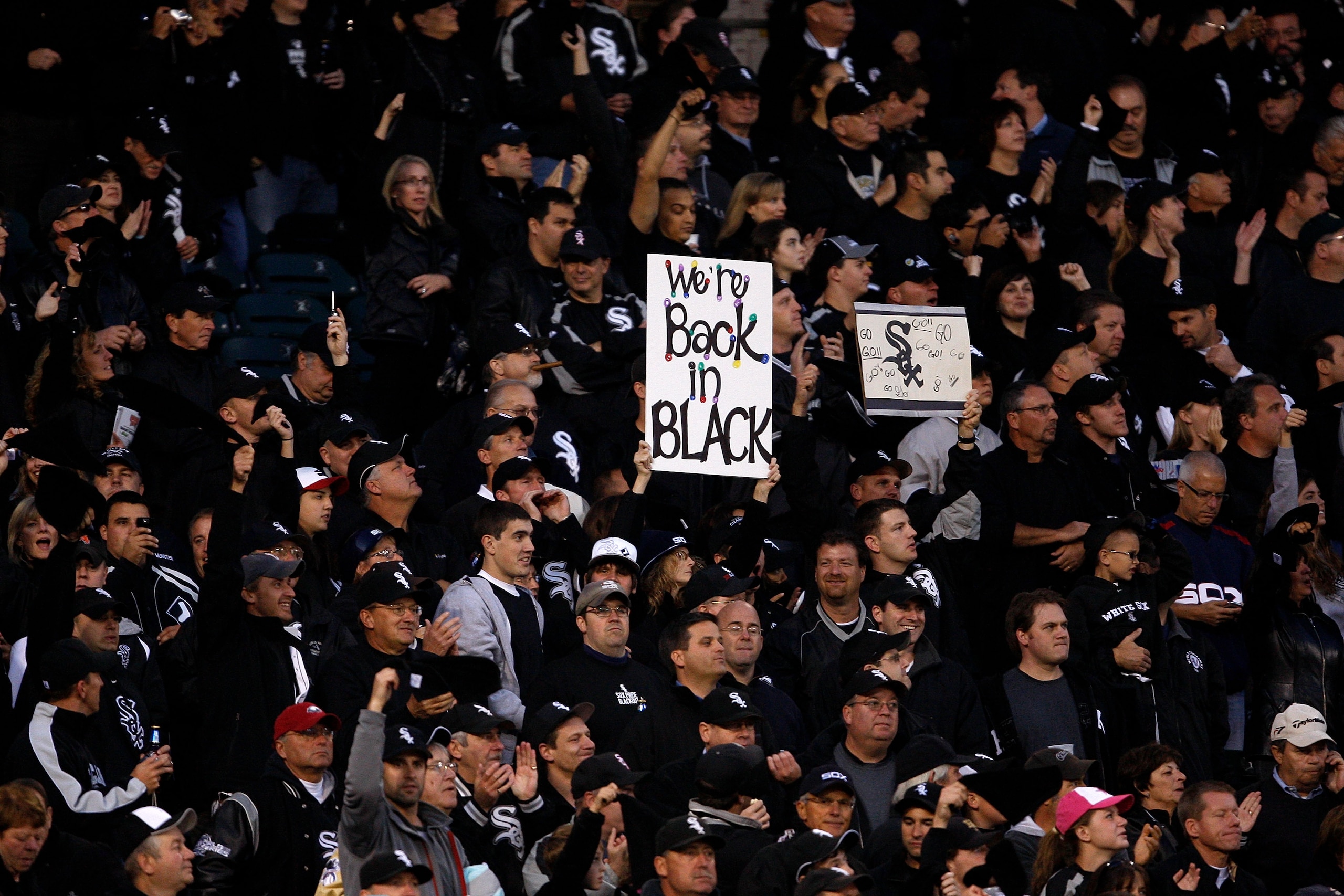 CHICAGO - SEPTEMBER 30:  A fan of the Chicago White Sox holds up a sign which reads 'We're back in black' in reference to all the fans wearing black for the game against the Minnesota Twins during the American League Central Division Tiebreaker game at U.