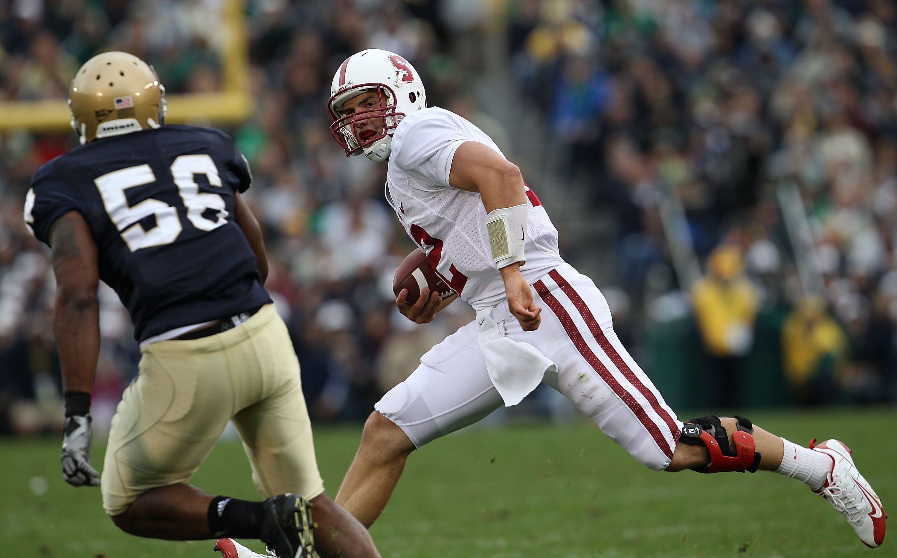 SOUTH BEND, IN - SEPTEMBER 25: Andrew Luck #12 of the Stanford Cardinal runs for yardage as Kerry Neal #56 of the Notre Dame Fighting Irish closes in at Notre Dame Stadium on September 25, 2010 in South Bend, Indiana. Stanford defeated Notre Dame 37-14. (