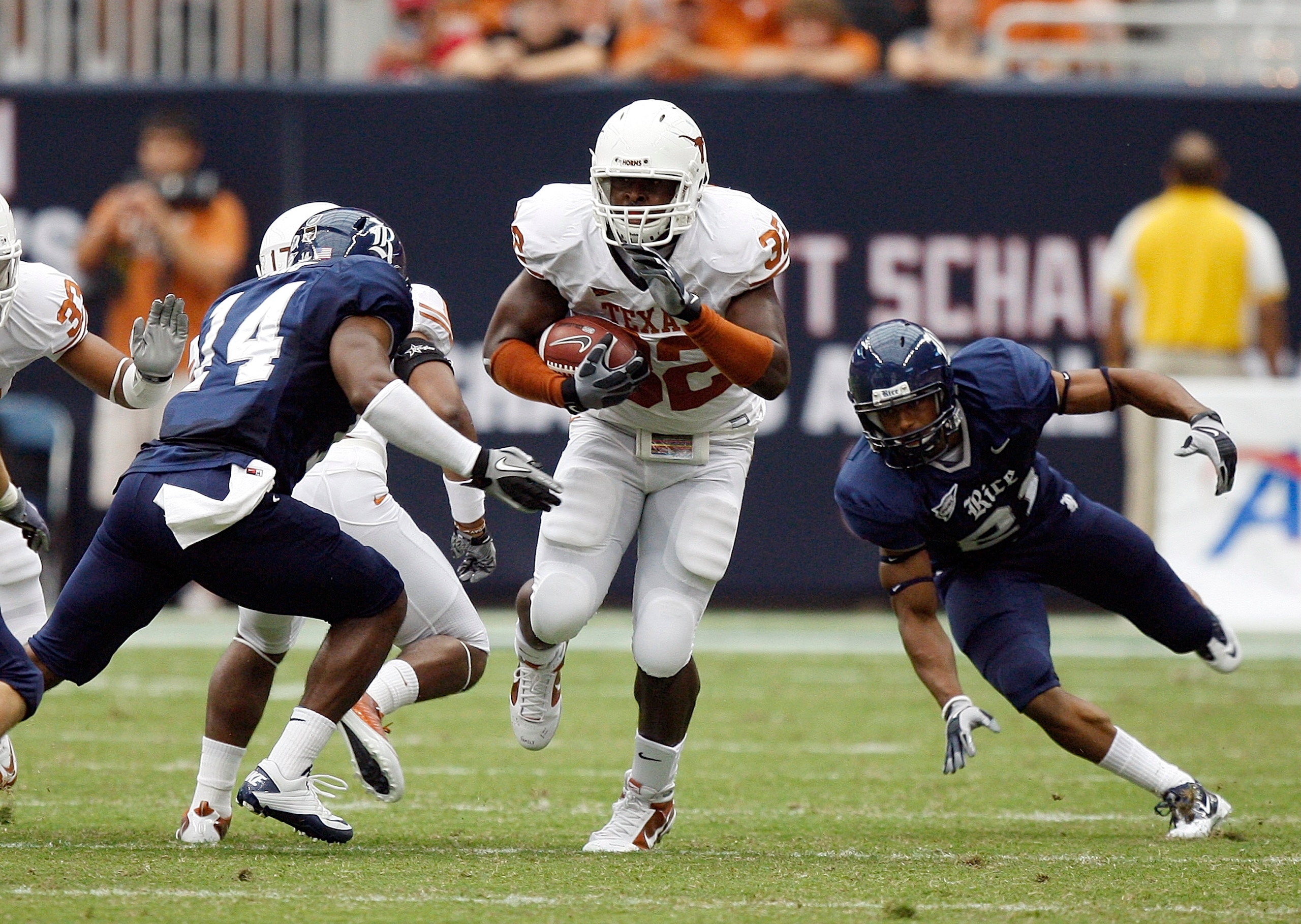 HOUSTON - SEPTEMBER 04: Running back Traylon Shead #32 of the Texas Longhorns splits the defense of safety Xavier Webb #14 and safety Denzel Wells #21 of the Rice Owls at Reliant Stadium on September 4, 2010 in Houston, Texas. Texas beat Rice 34-17. (Ph HOUSTON - SEPTEMBER 04: Running back Traylon Shead #32 of the Texas Longhorns splits the defense of safety Xavier Webb #14 and safety Denzel Wells #21 of the Rice Owls at Reliant Stadium on September 4, 2010 in Houston, Texas. Texas beat Rice 34-17. (Ph