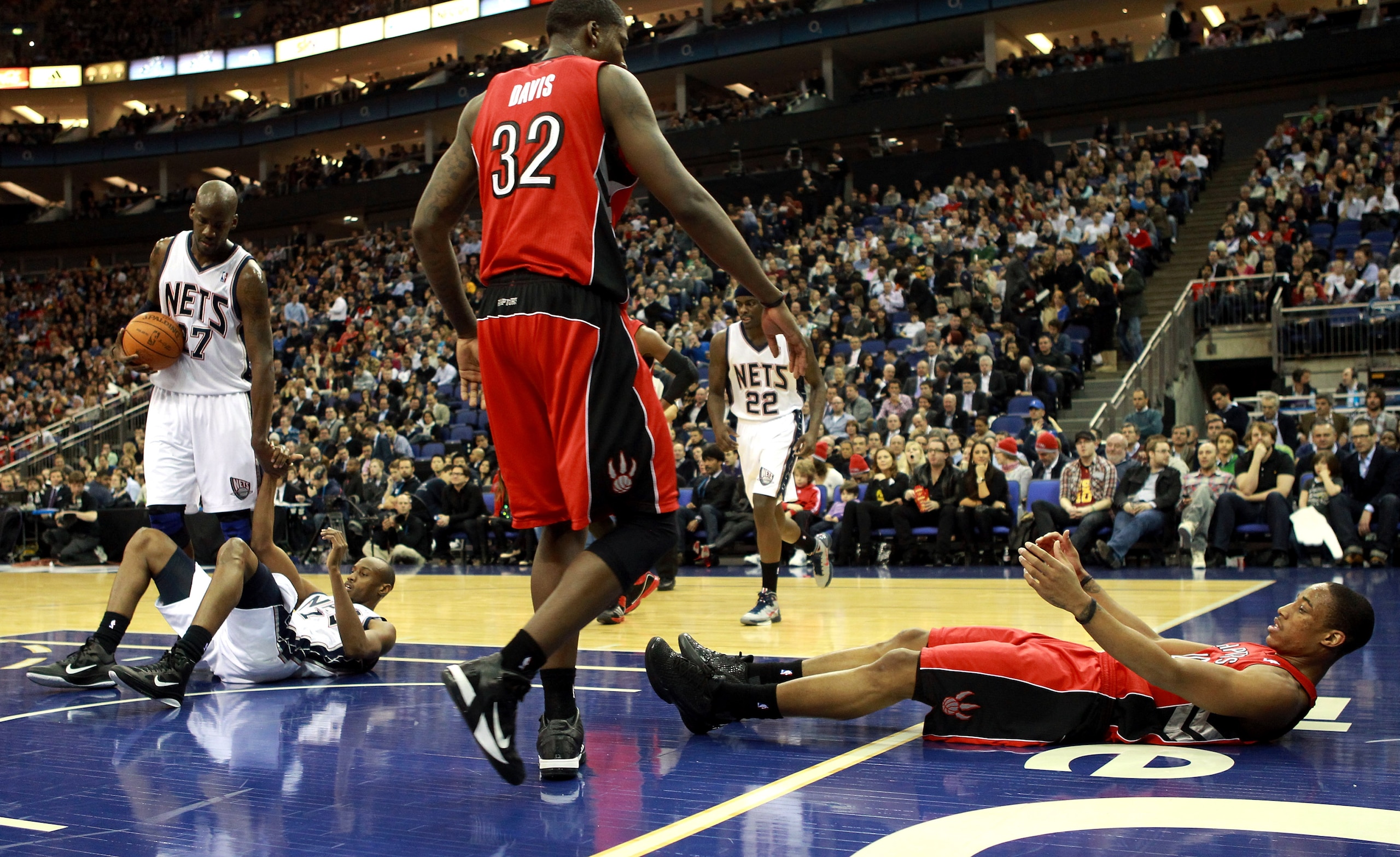 LONDON, ENGLAND - MARCH 04:  #10 DeMar DeRozan of the Raptorsis helped to his feet by team mate #32 Ed Davis during the NBA match between New Jersey Nets and the Toronto Raptors at the O2 Arena on March 4, 2011 in London, England. NOTE TO USER: User expre