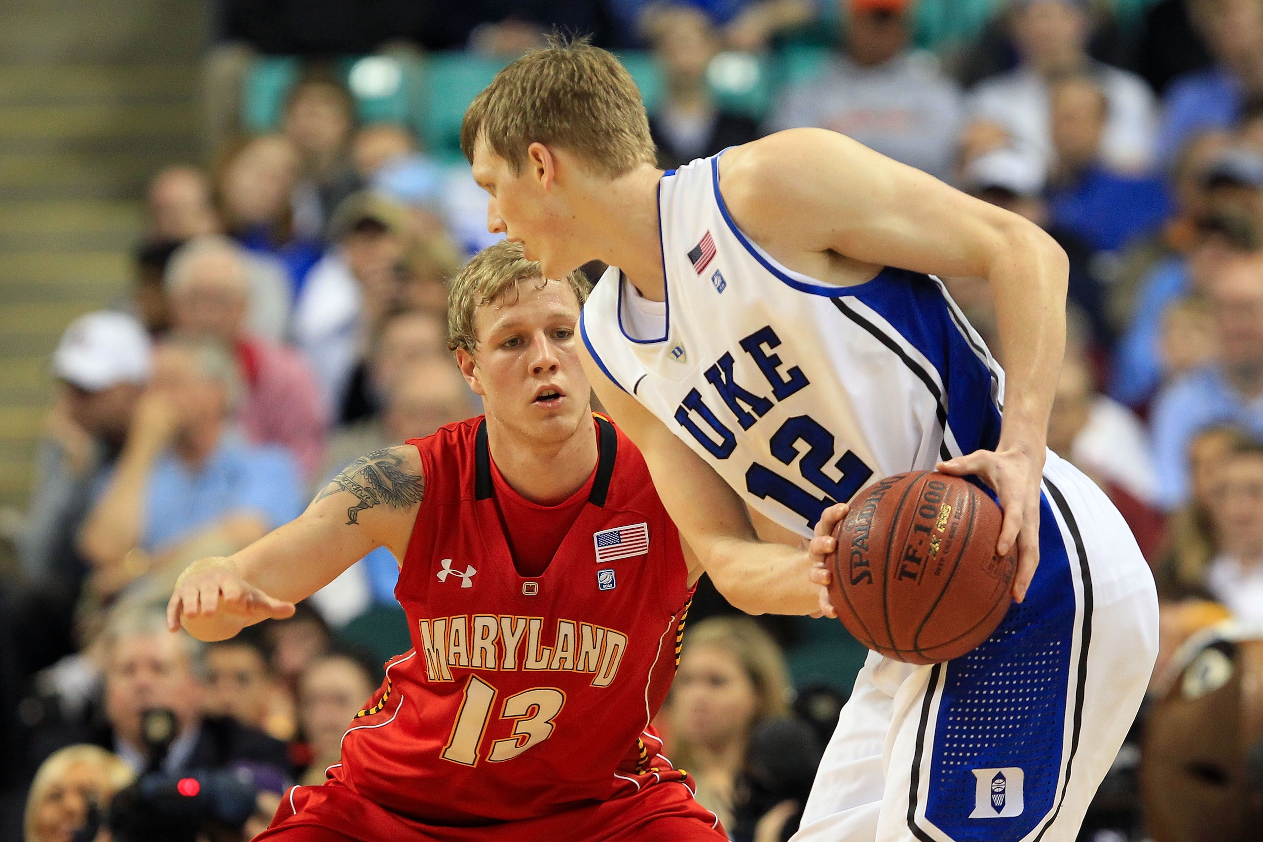 GREENSBORO, NC - MARCH 11:  Kyle Singler #12 of the Duke Blue Devils looks to drive against Haukur Palsson #13 of the Maryland Terrapins during the first half in the quarterfinals of the 2011 ACC men's basketball tournament at the Greensboro Coliseum on M