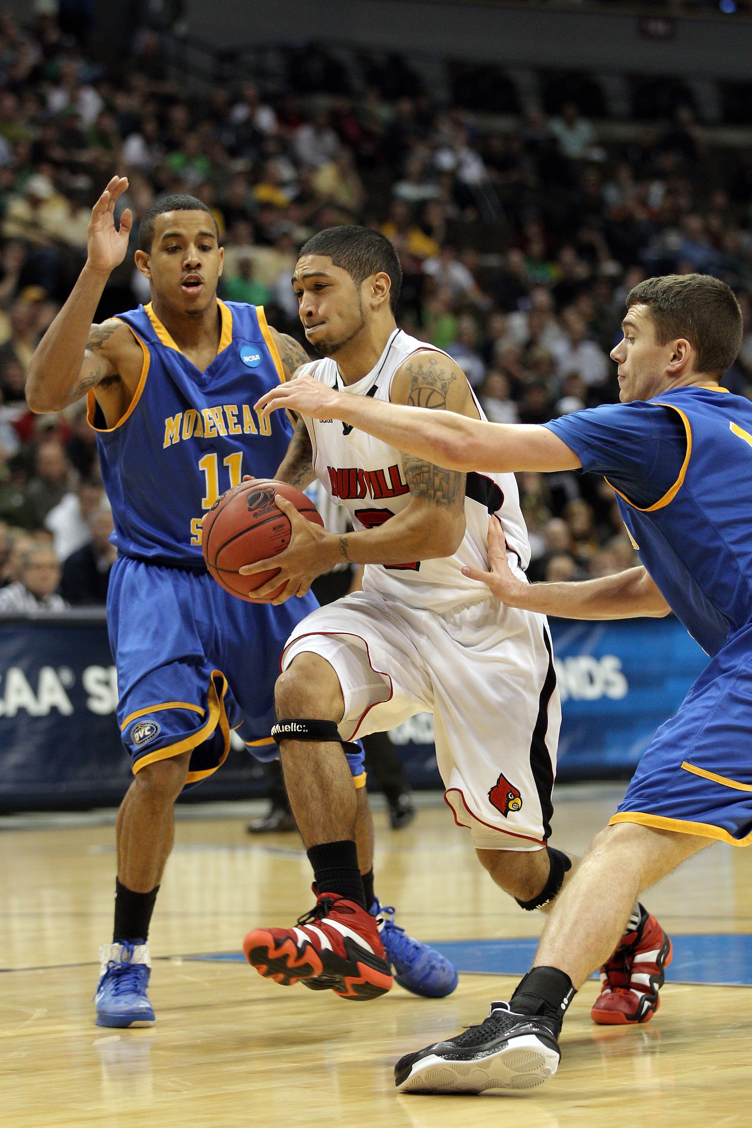 DENVER, CO - MARCH 17: Peyton Siva #3 of the Louisville Cardinals drives against Ty Proffitt #13 of the Morehead State Eagles and Terrance Hill #11 during the second round of the 2011 NCAA men's basketball tournament at Pepsi Center on March 17, 2011 in DENVER, CO - MARCH 17: Peyton Siva #3 of the Louisville Cardinals drives against Ty Proffitt #13 of the Morehead State Eagles and Terrance Hill #11 during the second round of the 2011 NCAA men's basketball tournament at Pepsi Center on March 17, 2011 in