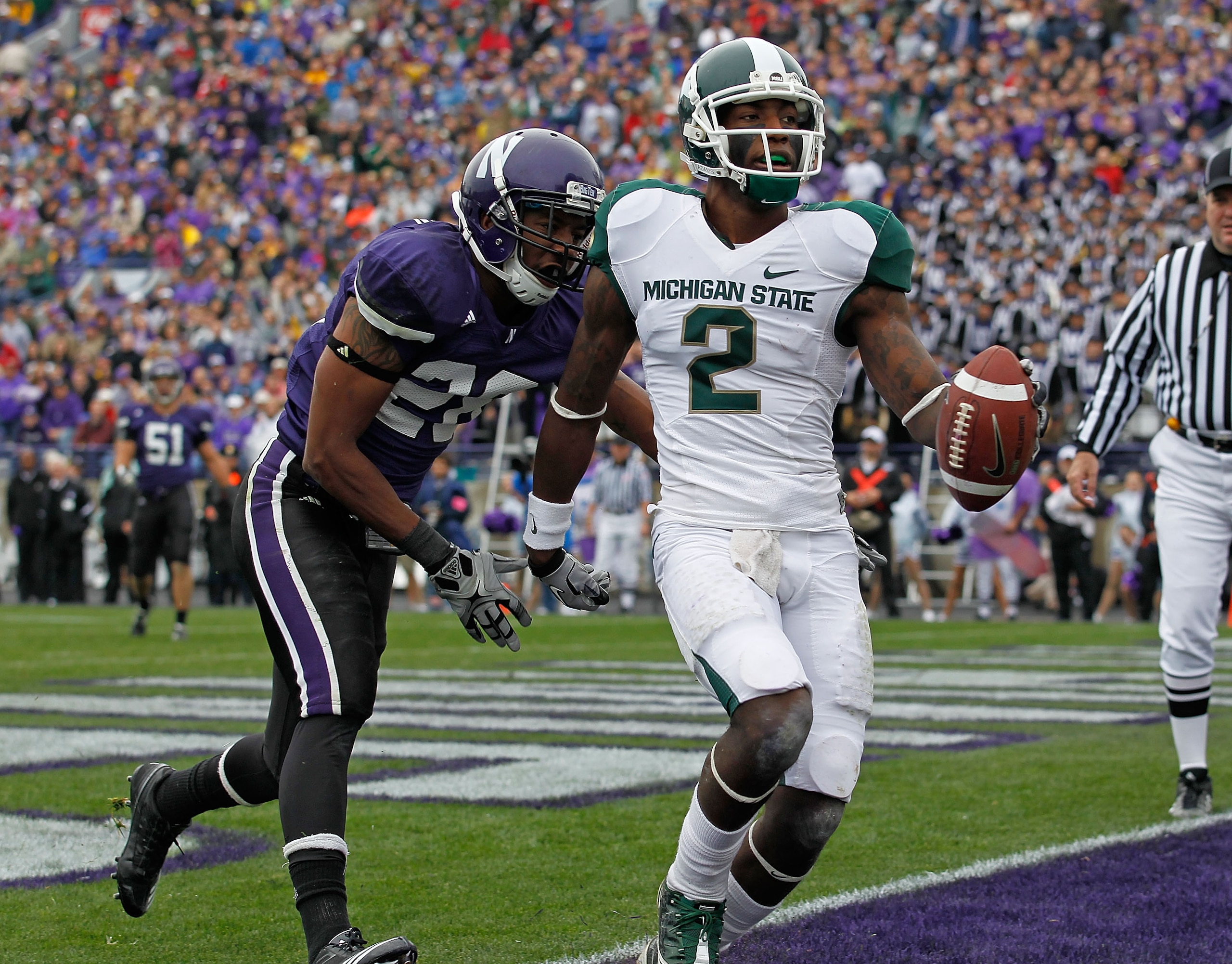 EVANSTON, IL - OCTOBER 23: Mark Dell #2 of the Michigan State Spartans scores a touchdown in front of Justan Vaughn #28 of the Northwestern Wildcats at Ryan Field on October 23, 2010 in Evanston, Illinois. Michigan State defeated Northwestern 35-27. (Phot