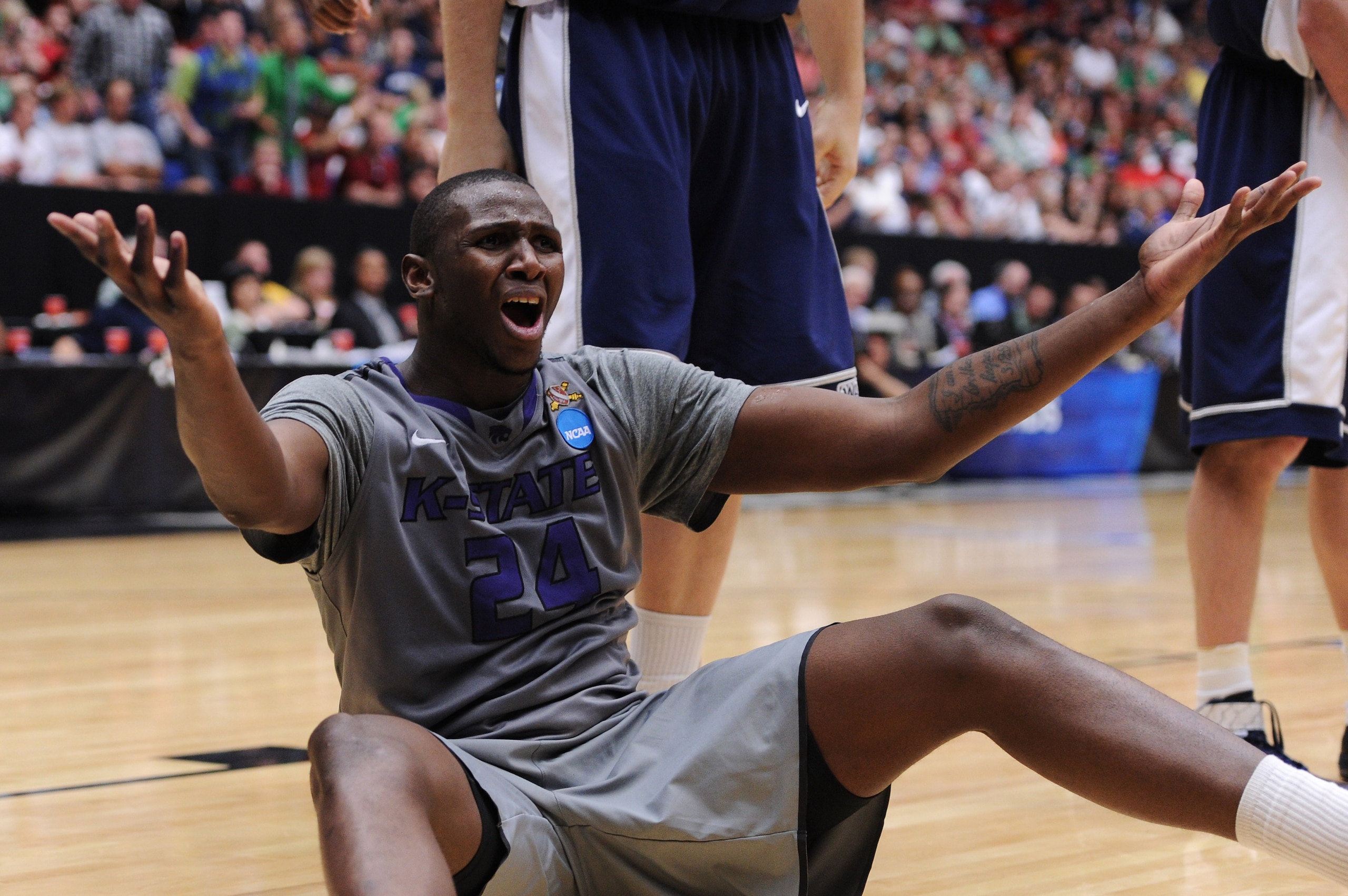 TUCSON, AZ - MARCH 17:  Curtis Kelly #24 of the Kansas State Wildcats reacts after he is knocked to the ground by Brady Jardine #22 of the Utah State Aggies and fails to draw a foul during the second round of the 2011 NCAA men's basketball tournament at M