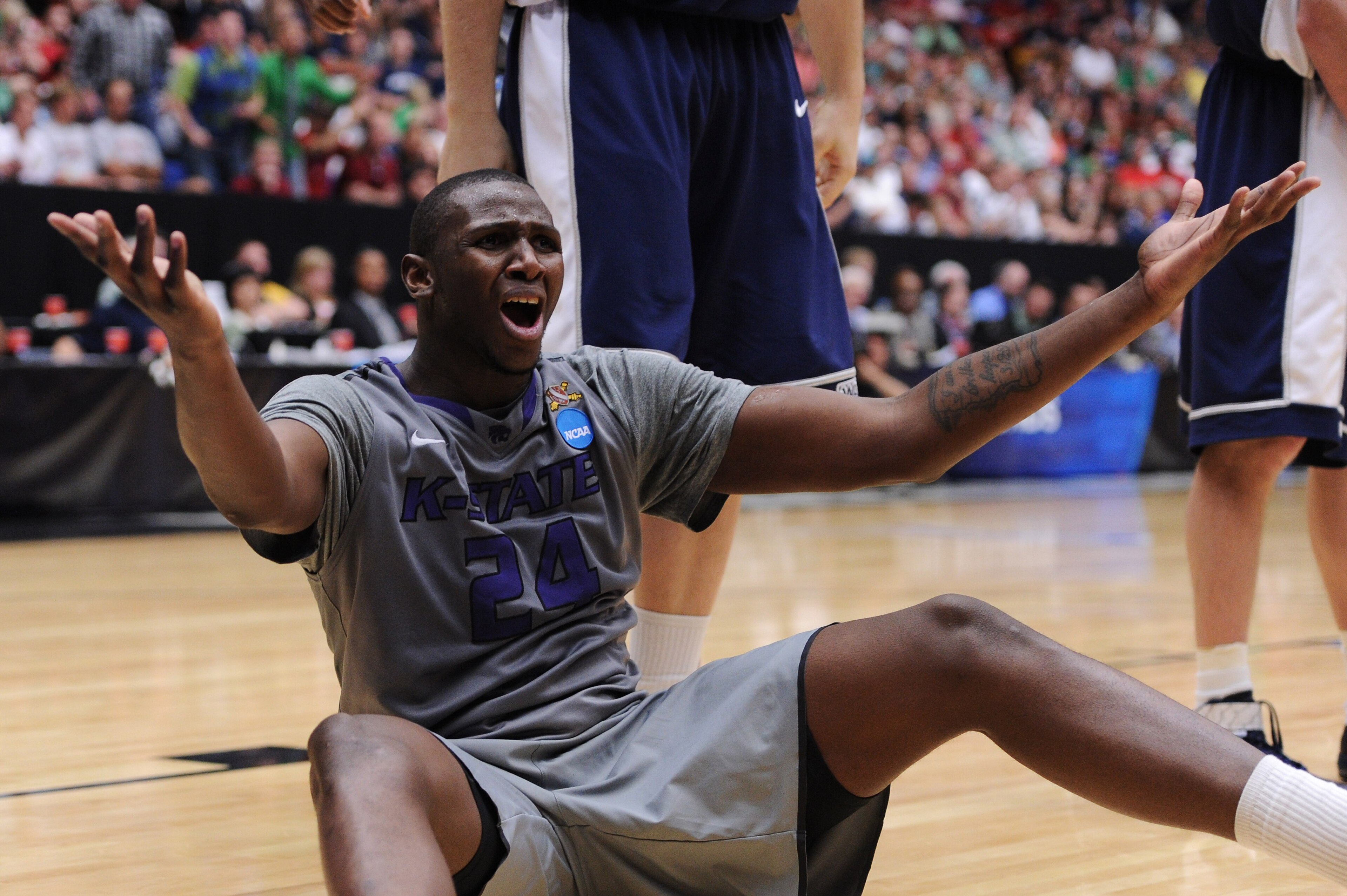 TUCSON, AZ - MARCH 17:  Curtis Kelly #24 of the Kansas State Wildcats reacts after he is knocked to the ground by Brady Jardine #22 of the Utah State Aggies and fails to draw a foul during the second round of the 2011 NCAA men's basketball tournament at M