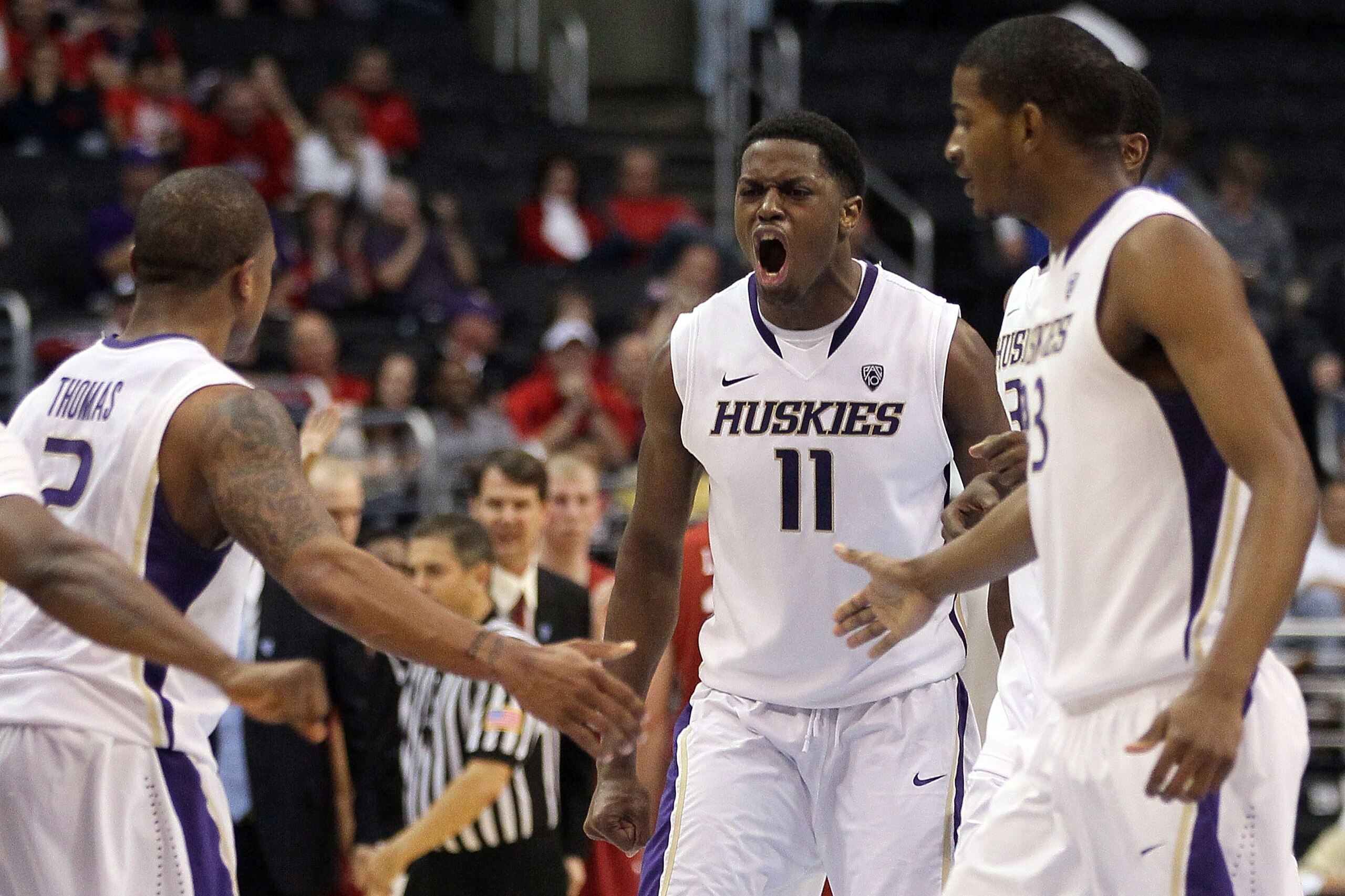 LOS ANGELES, CA - MARCH 10:  Matthew Bryan-Amaning #11 of the Washington Huskies reacts with teammates Isaiah Thomas #2 and C.J. Wilcox #23 in the second half while taking on the Washington State Cougars in the quarterfinals of the 2011 Pacific Life Pac-1
