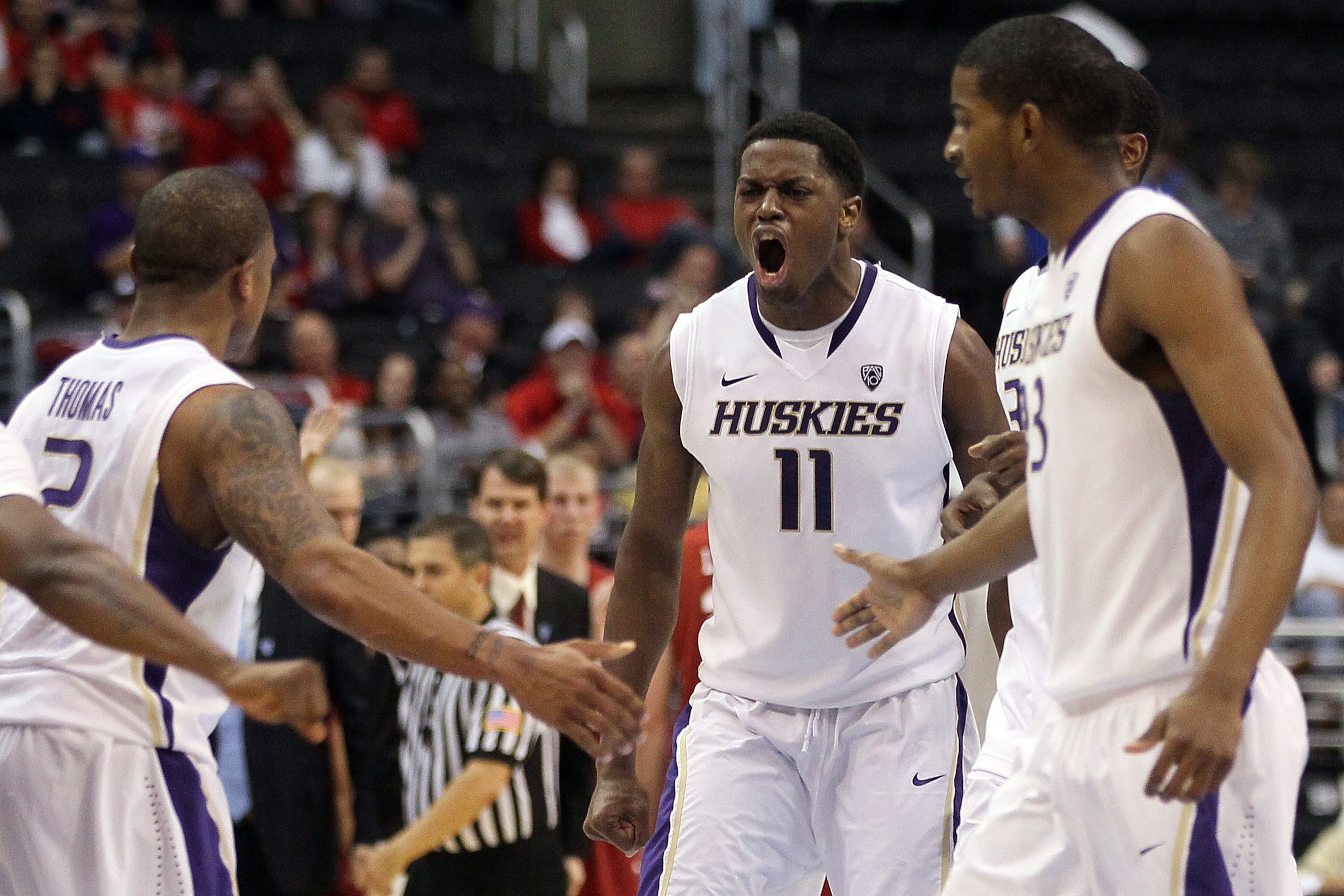 LOS ANGELES, CA - MARCH 10:  Matthew Bryan-Amaning #11 of the Washington Huskies reacts with teammates Isaiah Thomas #2 and C.J. Wilcox #23 in the second half while taking on the Washington State Cougars in the quarterfinals of the 2011 Pacific Life Pac-1