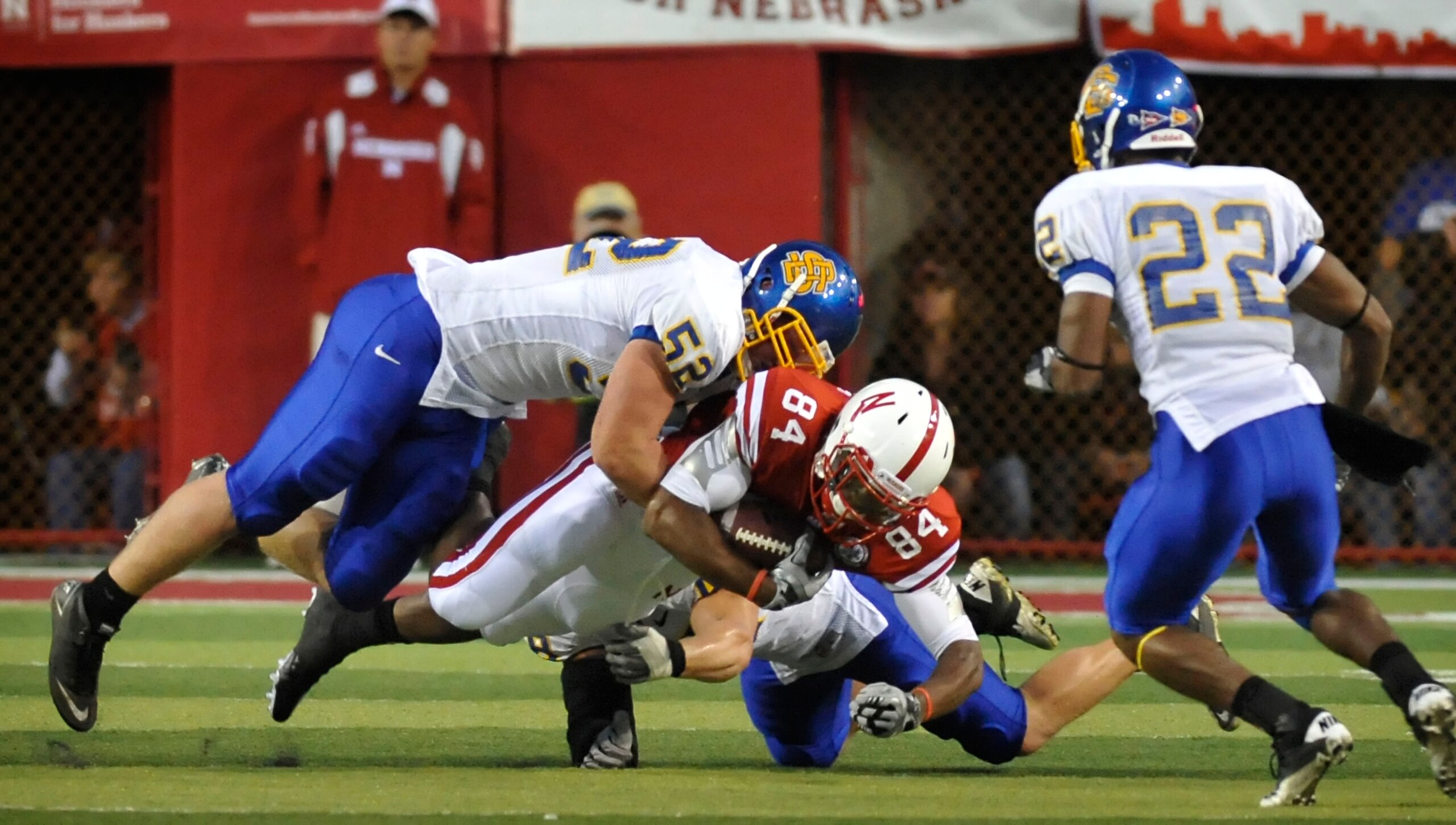 LINCOLN, NE - SEPTEMBER 25: Wide receiver Brandon Kinnie #84 of the Nebraska Cornhuskers gets tackled by by defensive tackle Andy Mink #52 cornerback Anthony Wise #22 of the South Dakota State Jackrabbits during first half action of their game at Memorial
