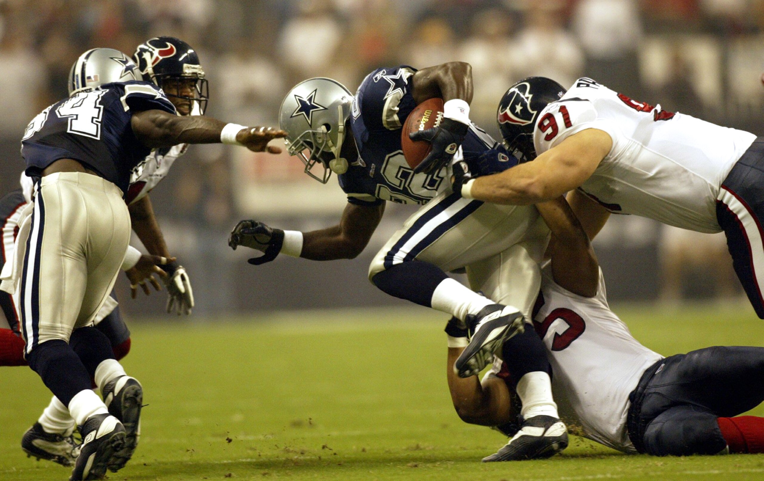 HOUSTON - SEPTEMBER 8:  Running back Emmitt Smith #22 of the Dallas Cowboys is tackled by Seth Payne #91 of the Houston Texans on September 8, 2002 at Reliant Stadium in Houston, Texas. The Texans defeated the Cowboys 19-10 for the first win in franchise
