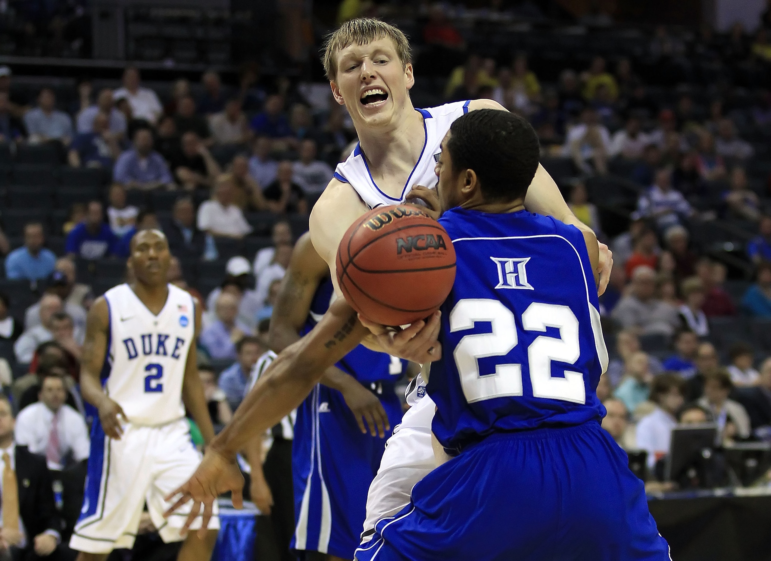 CHARLOTTE, NC - MARCH 18:  Kyle Singler #12 of the Duke Blue Devils goes up against Christopher Tolson #22 of the Hampton Pirates in the second half during the second round of the 2011 NCAA men's basketball tournament at Time Warner Cable Arena on March 1