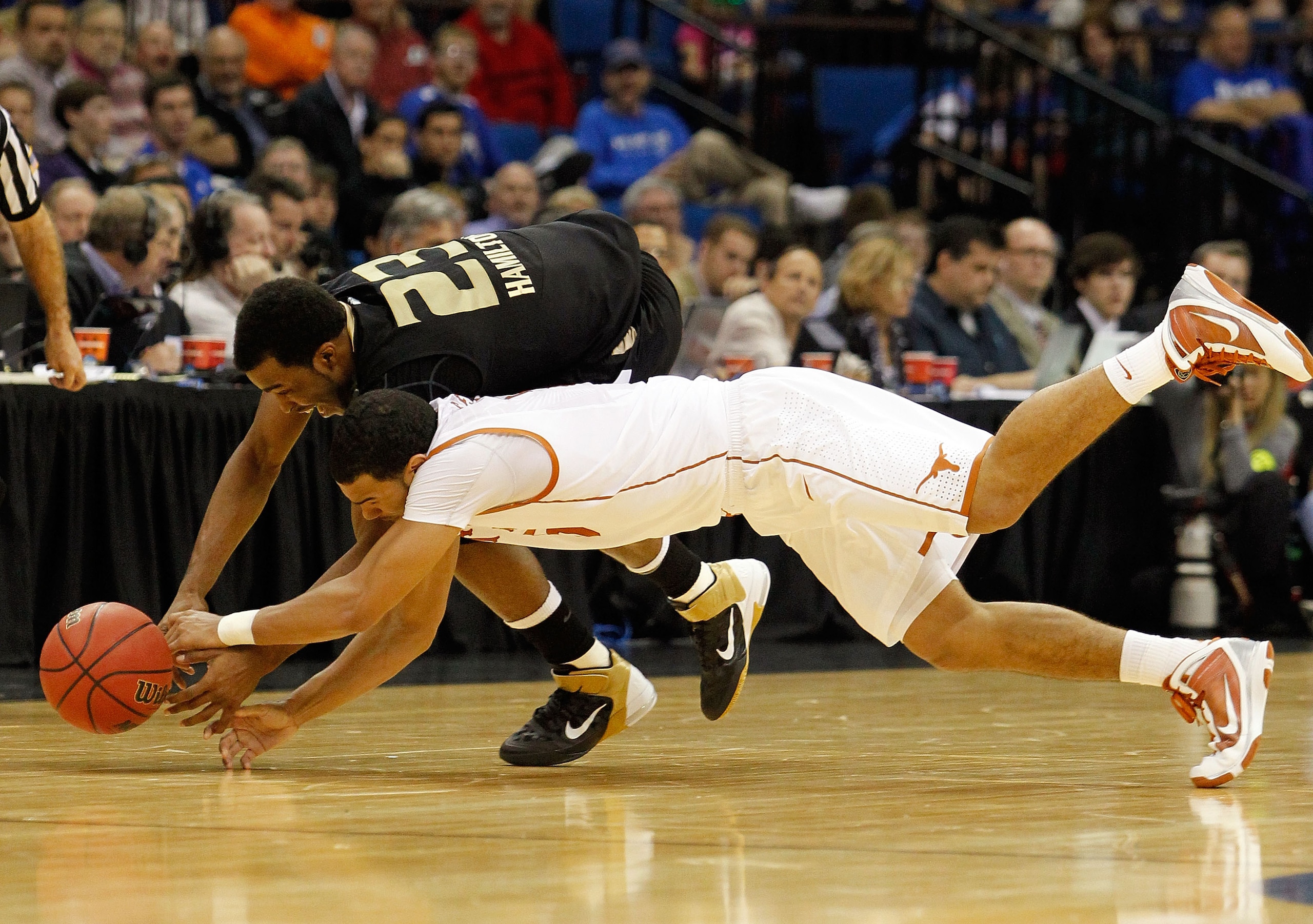 TULSA, OK - MARCH 18: Reggie Hamilton #23 of the Oakland Golden Grizzlies and Cory Joseph #5 of the Texas Longhorns dive for a loose ball during the second round of the 2011 NCAA men's basketball tournament at BOK Center on March 18, 2011 in Tulsa, Oklah TULSA, OK - MARCH 18: Reggie Hamilton #23 of the Oakland Golden Grizzlies and Cory Joseph #5 of the Texas Longhorns dive for a loose ball during the second round of the 2011 NCAA men's basketball tournament at BOK Center on March 18, 2011 in Tulsa, Oklah