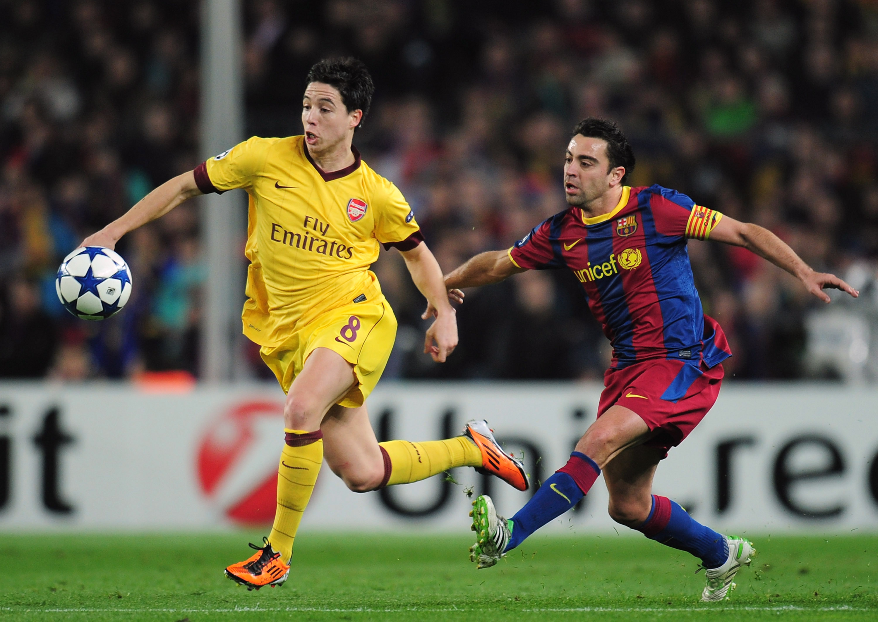 BARCELONA, SPAIN - MARCH 08:   Samir Nasri (L) of Arsenal is challenged by Xavi Hernandez of Barcelona during the UEFA Champions League round of 16 second leg match between Barcelona and Arsenal at the Nou Camp Stadium on March 8, 2011 in Barcelona, Spain