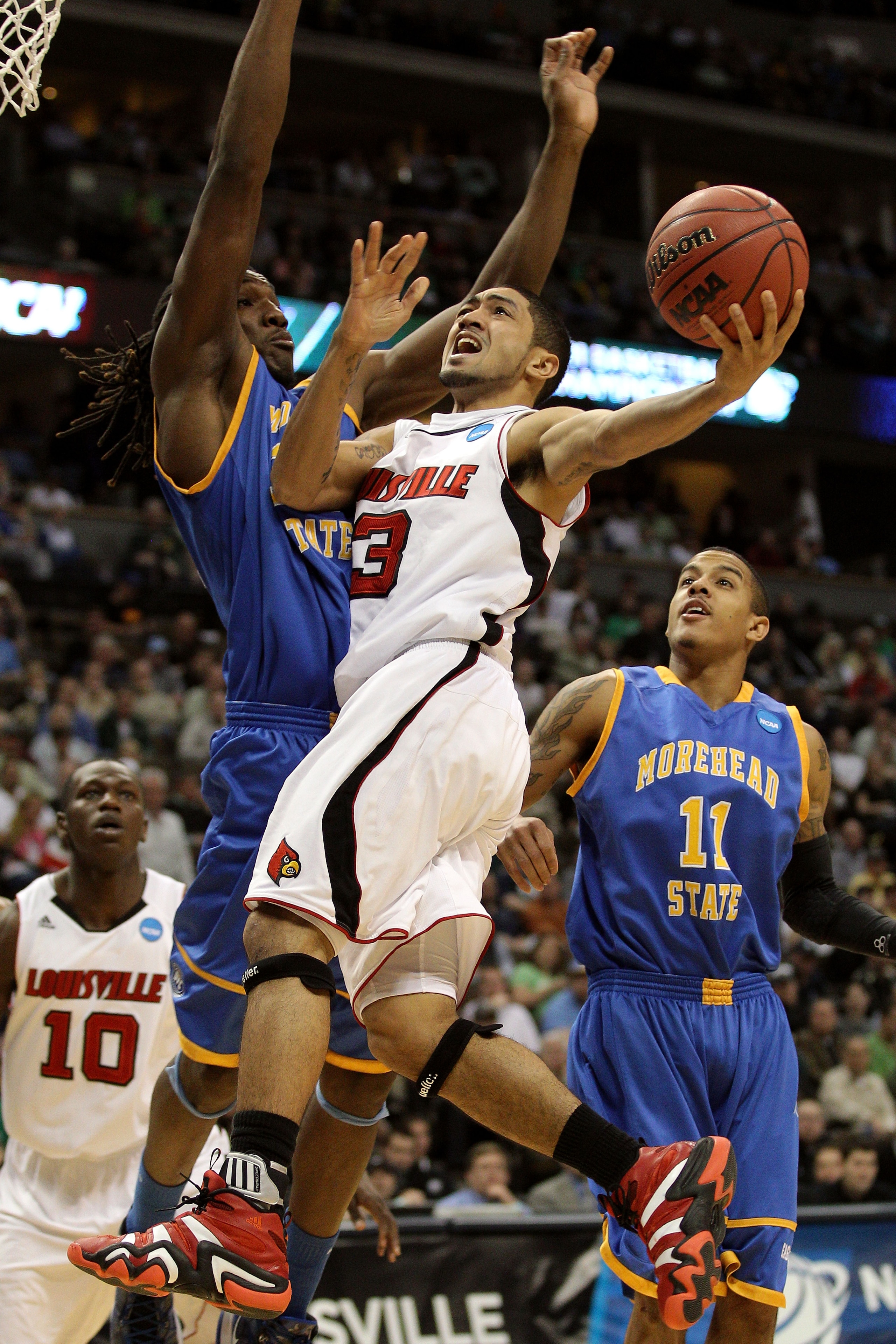 DENVER, CO - MARCH 17:  Peyton Siva #3 of the Louisville Cardinals drives against Kenneth Faried #35 of the Morehead State Eagles and Terrance Hill #11 during the second round of the 2011 NCAA men's basketball tournament at Pepsi Center on March 17, 2011