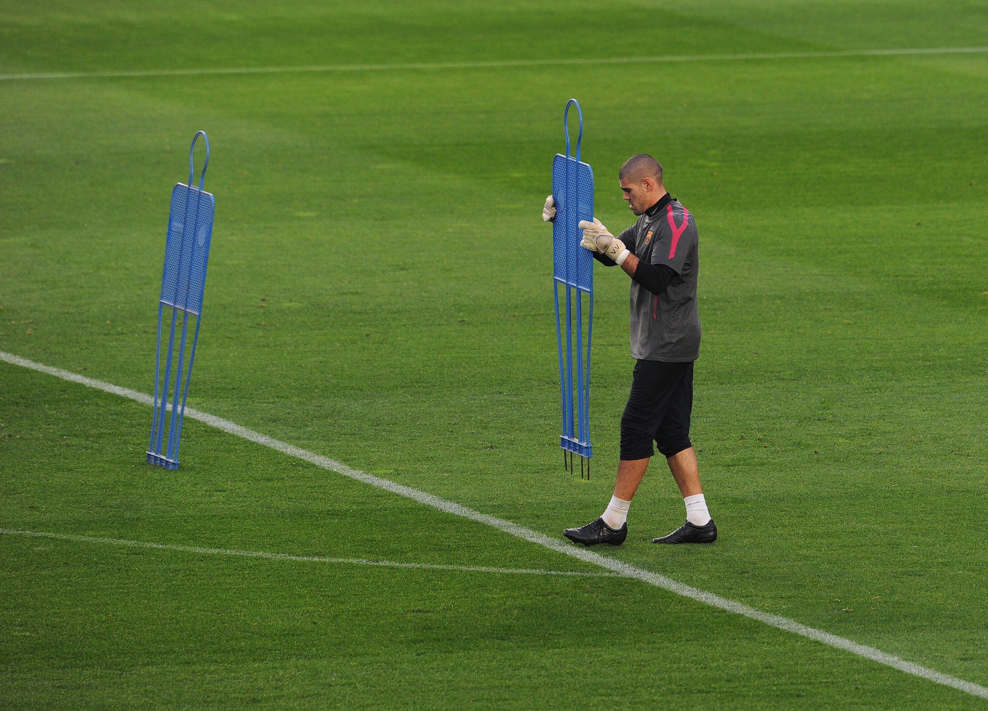BARCELONA, SPAIN - MARCH 07:  Goalkeeper Victor Valdes of Barcelona carries a piece of training equipment during a training session ahead of their UEFA Champions League round of 16 second leg match against Arsenal at the Camp Nou stadium on March 7, 2011