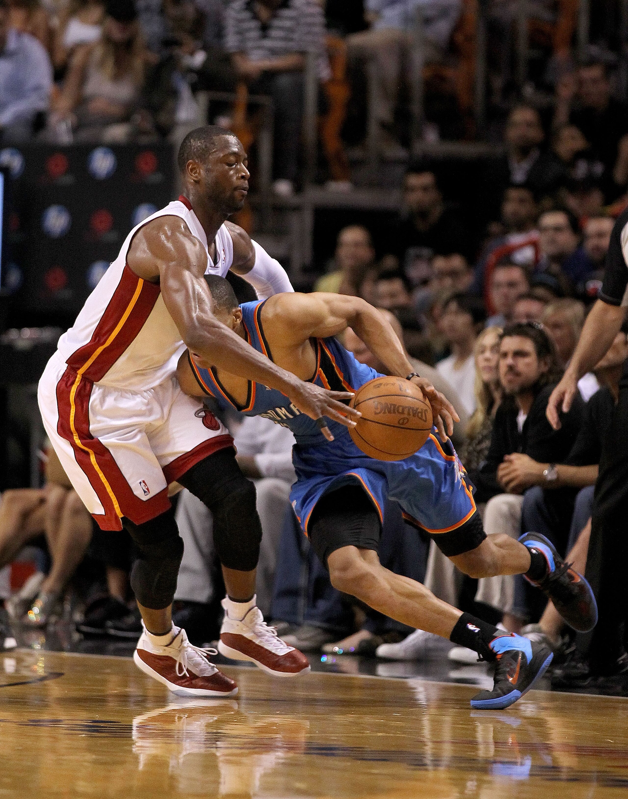 MIAMI, FL - MARCH 16:  Russell Westbrook #0 of the the Oklahoma City Thunder dribbles into Dwyane Wade #3 of the Miami Heat during a game at American Airlines Arena on March 16, 2011 in Miami, Florida. NOTE TO USER: User expressly acknowledges and agrees