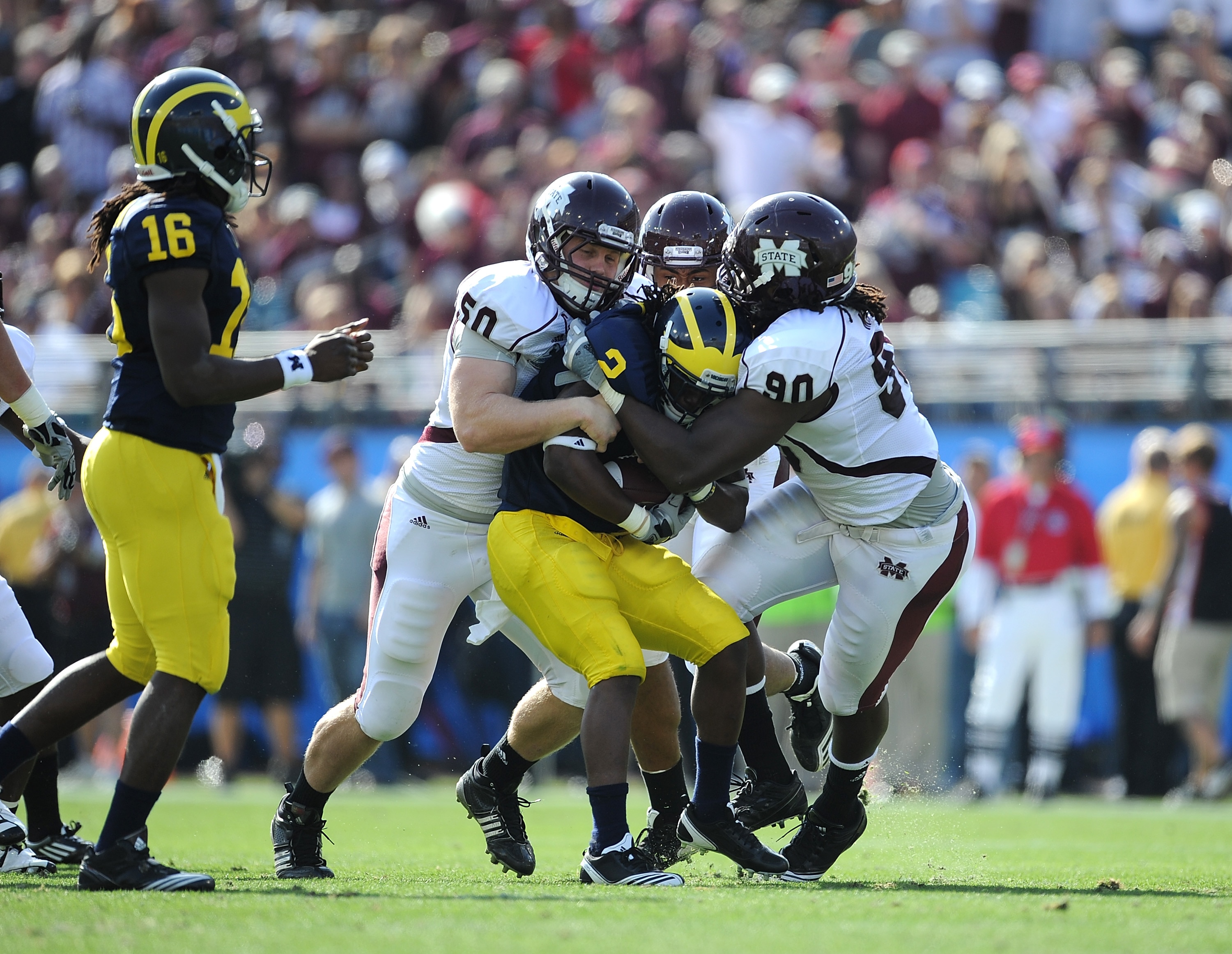 JACKSONVILLE, FL - JANUARY 01: Chris White #50 and Pernell McPhee #90 of the Mississippi State Bulldogs tackle Vincent Smith # 2 of the Michigan Wolverines during the Gator Bowl at EverBank Field on January 1, 2011 in Jacksonville, Florida (Photo by Ric JACKSONVILLE, FL - JANUARY 01: Chris White #50 and Pernell McPhee #90 of the Mississippi State Bulldogs tackle Vincent Smith # 2 of the Michigan Wolverines during the Gator Bowl at EverBank Field on January 1, 2011 in Jacksonville, Florida (Photo by Ric