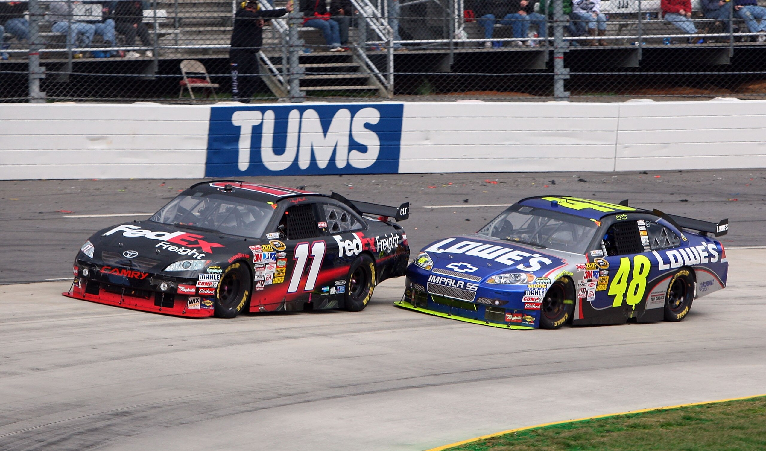 MARTINSVILLE, VA - MARCH 29: Jimmie Johnson, driver of the #48 Lowe's Chevrolet, bumps Denny Hamlin, driver of the #11 FedEx Express Toyota, to make a pass during the NASCAR Sprint Cup Series Goody's Fast Pain Relief 500 at the Martinsville Speedway on Ma