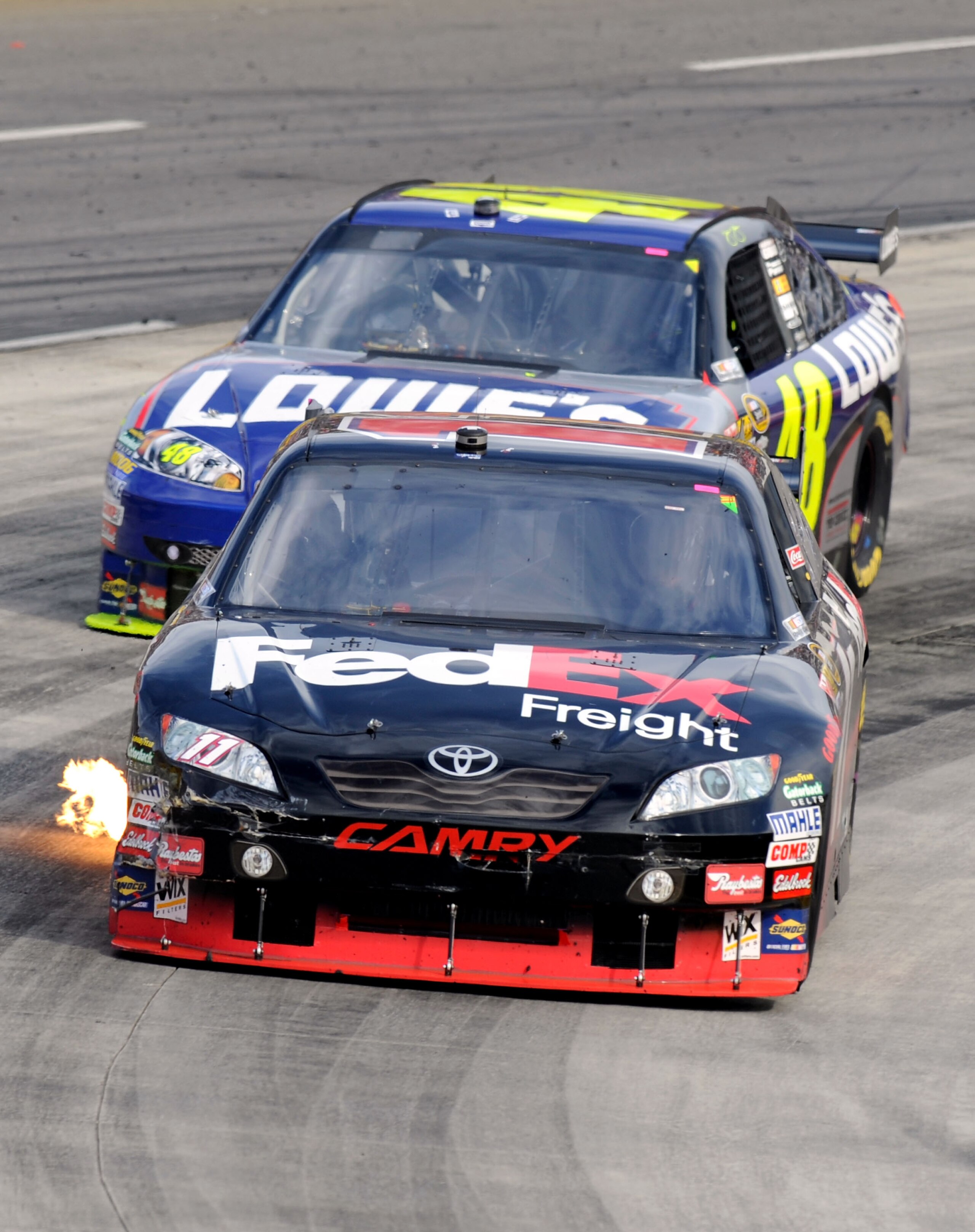 MARTINSVILLE, VA - OCTOBER 25:  Denny Hamlin, driver of the #11 FedEx Freight Toyota, leads Jimmie Johnson, driver of the #48 Lowe's Chevrolet, during the NASCAR Sprint Cup Series TUMS Fast Relief 500 at Martinsville Speedway on October 25, 2009 in Martin