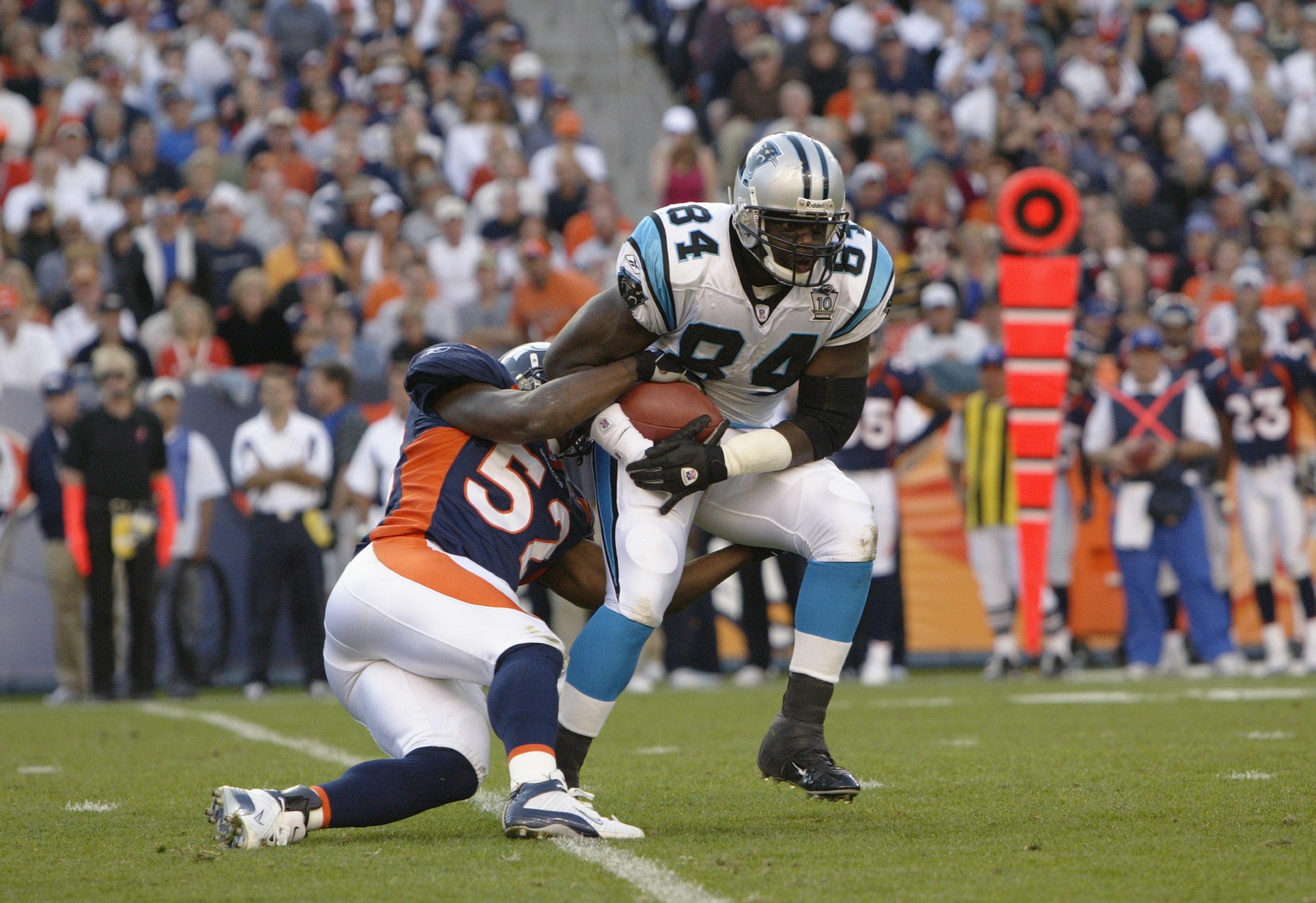 DENVER - OCTOBER 10:  Tight end Michael Gaines #84 the Carolina Panthers is tackled by linebcaker D.J. Williams #52 of the Denver Broncos during the game at Invesco Field on October 10, 2004 at Mile High Stadium in Denver, Colorado. The Broncos defeated t