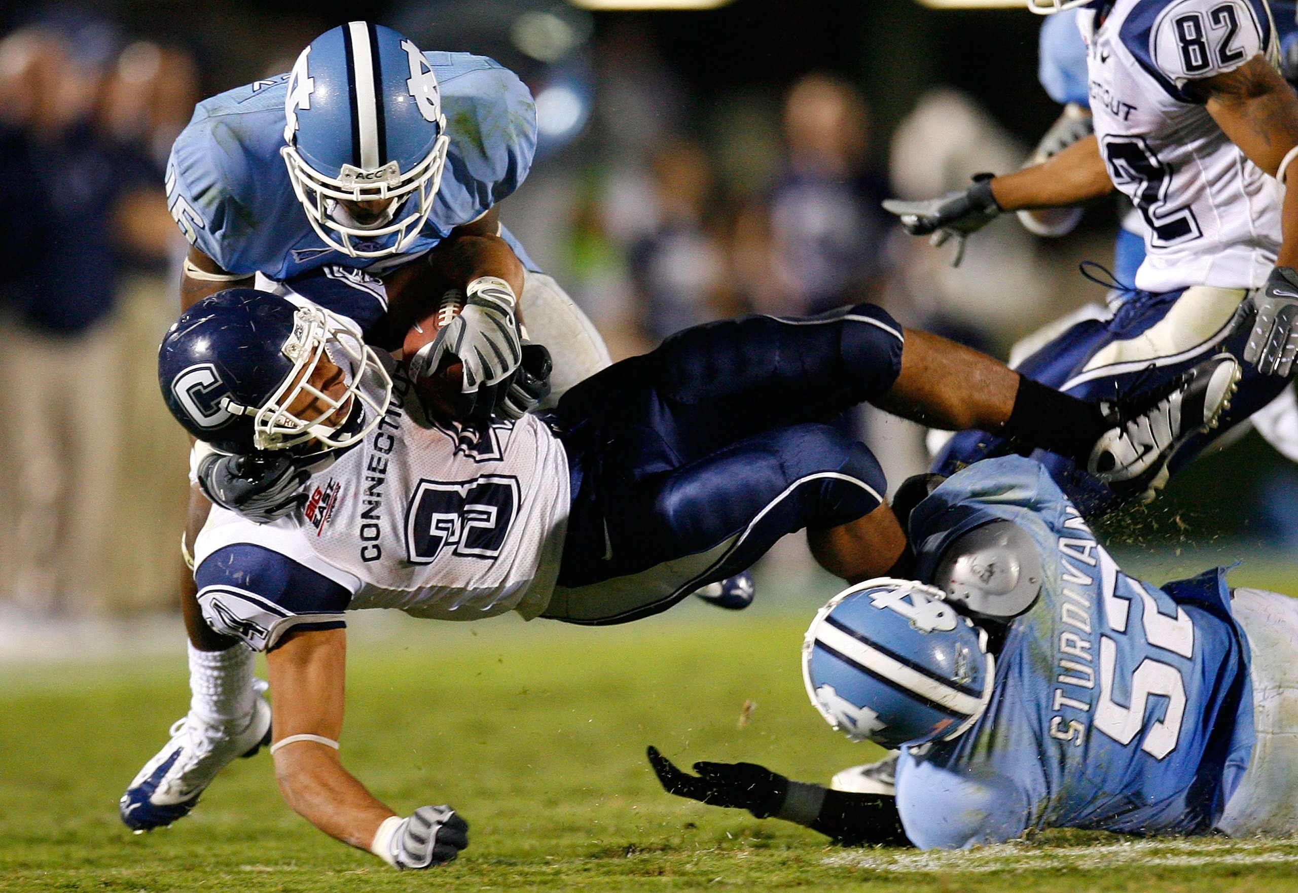 CHAPEL HILL, NC - OCTOBER 04:  Tailback Donald Brown #34 of the Connecticut Huskies is tackled by Kendric Burney #16 and Quan Sturdivant #52 of the North Carolina Tar Heels during the game at Kenan Stadium on October 4, 2008 in Chapel Hill, North Carolina