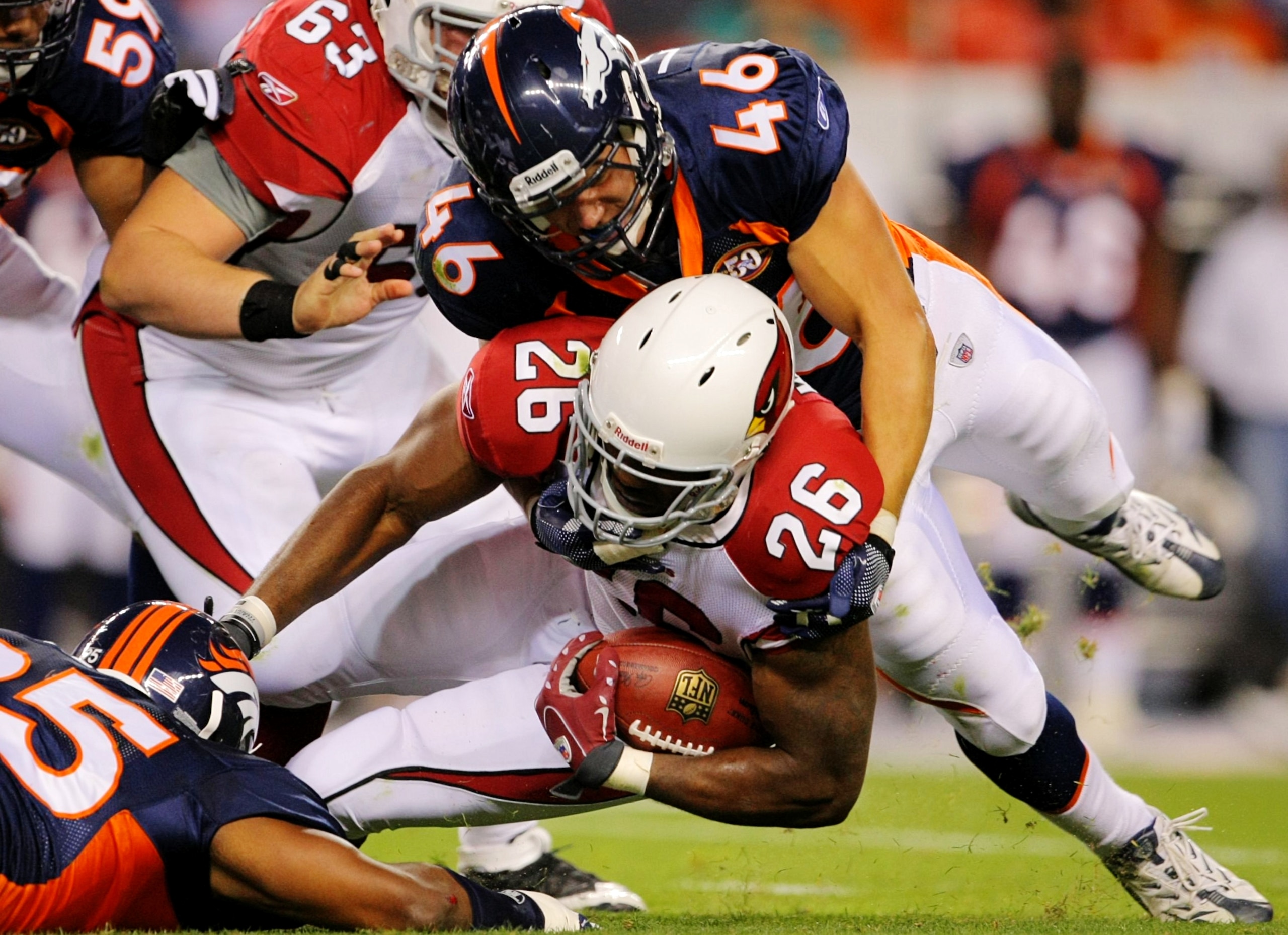 DENVER - SEPTEMBER 3: Spencer Larsen #46 of the Denver Broncos tackles running back Beanie Wells #26 of the Arizona Cardinals during the NFL preseason game at Invesco Field at Mile High on September 3, 2009 in Denver, Colorado.  (Photo by Doug Pensinger/G